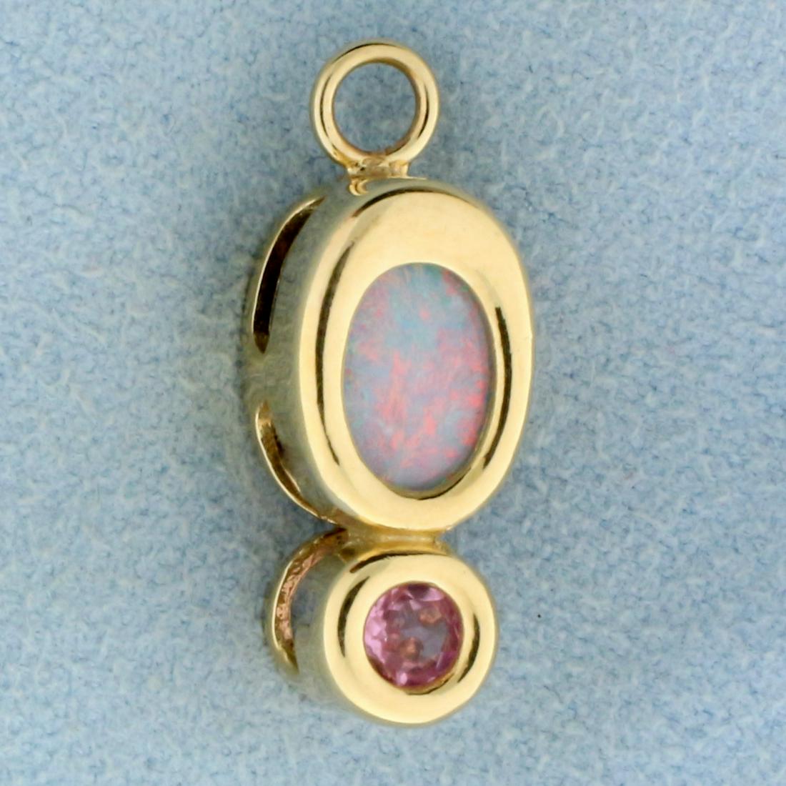 Black Opal and Morganite Pendant in 14k Yellow Gold: In 14k Yellow Gold. Contains one high quality natural 7x5mm oval Opal gemstone with intense play of color with flashes of orange, green, and purple. Also contains one high quality natural 1/5ct2. Morg
