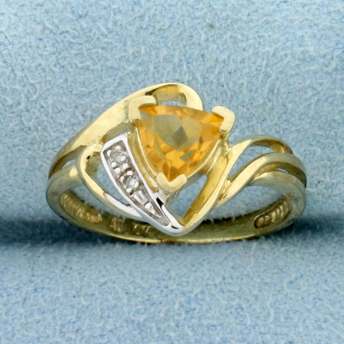 Citrine and Diamond Ring in 10K Yellow Gold: In 10K Yellow Gold. Contains one high quality natural 6mm trillion cut Citrine gemstone with bright yellow color and excellent clarity. Also contains two high quality 1/2pt Diamonds. Size 7 1/4. 2.4g.