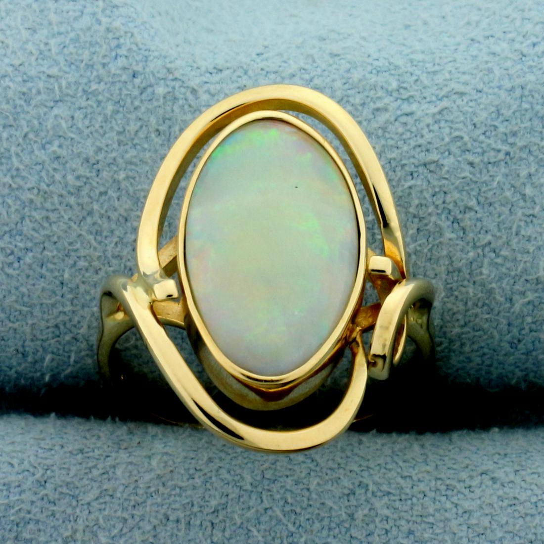 Opal Solitaire Ring in 14K Yellow Gold: In 14K Yellow Gold. Contains one high quality natural 15x9mm oval opal gemstone with intense play of color with flashes of green, orange, blue and red. Size 7. 4.5g