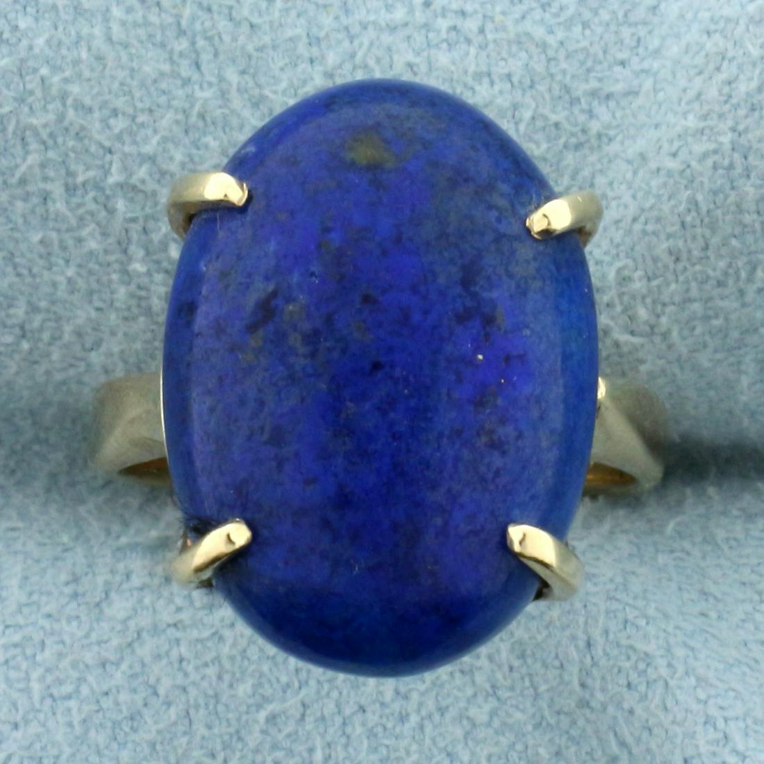 10ct Lapis Lazuli Solitaire Statement Ring in 14K: In 14K Yellow Gold. Contains one 18.2x 13.2mm oval cabochon Lapis gemstone with intense blue color with flecks of gold. Size 5.5. 5.4g