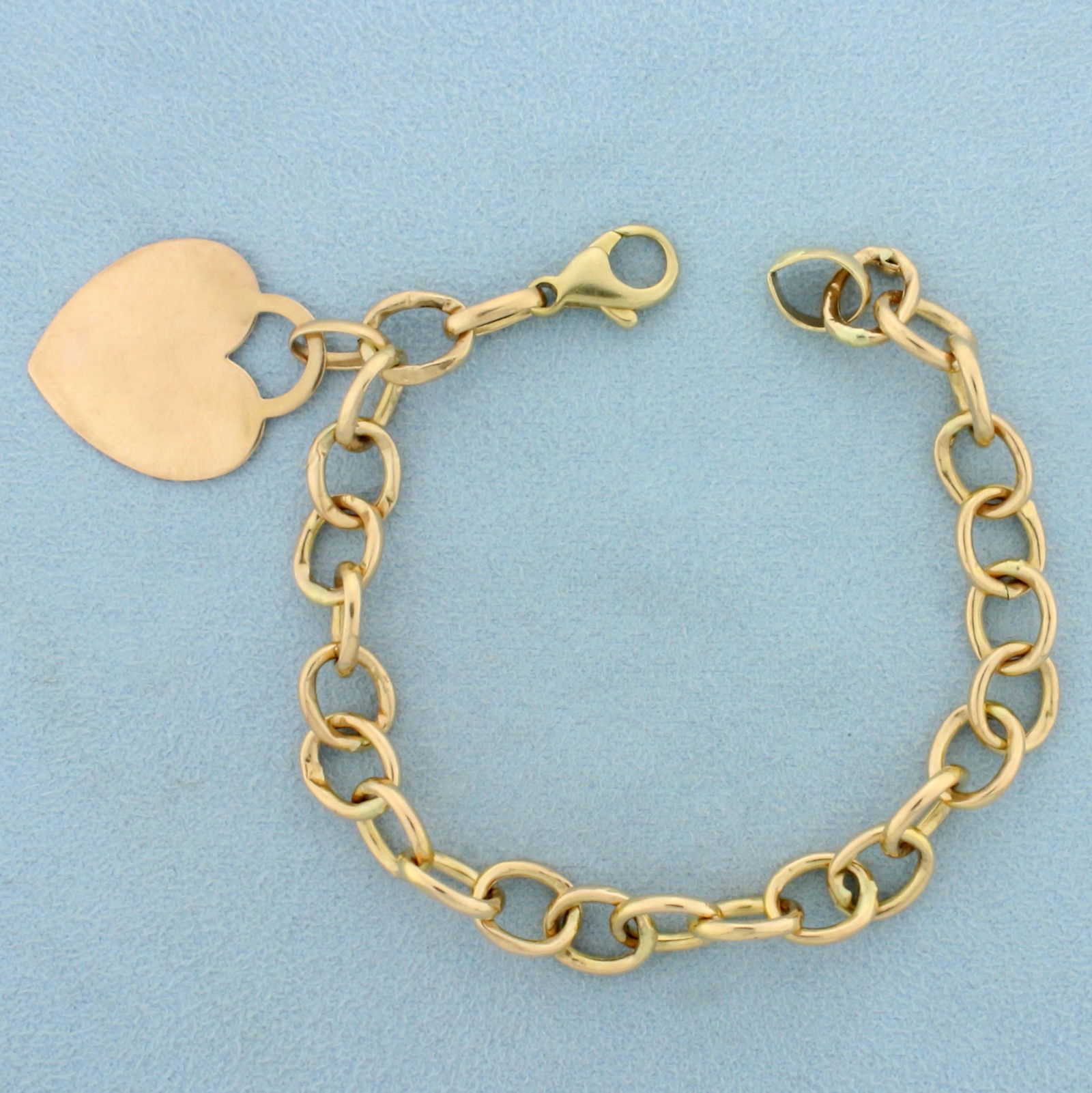 Cable Link Chain Bracelet With Heart Charm in 10K: In 10K Yellow Gold. 7 1/2 inches long, 5.6mm wide, with lobster clasp. 6.9g.