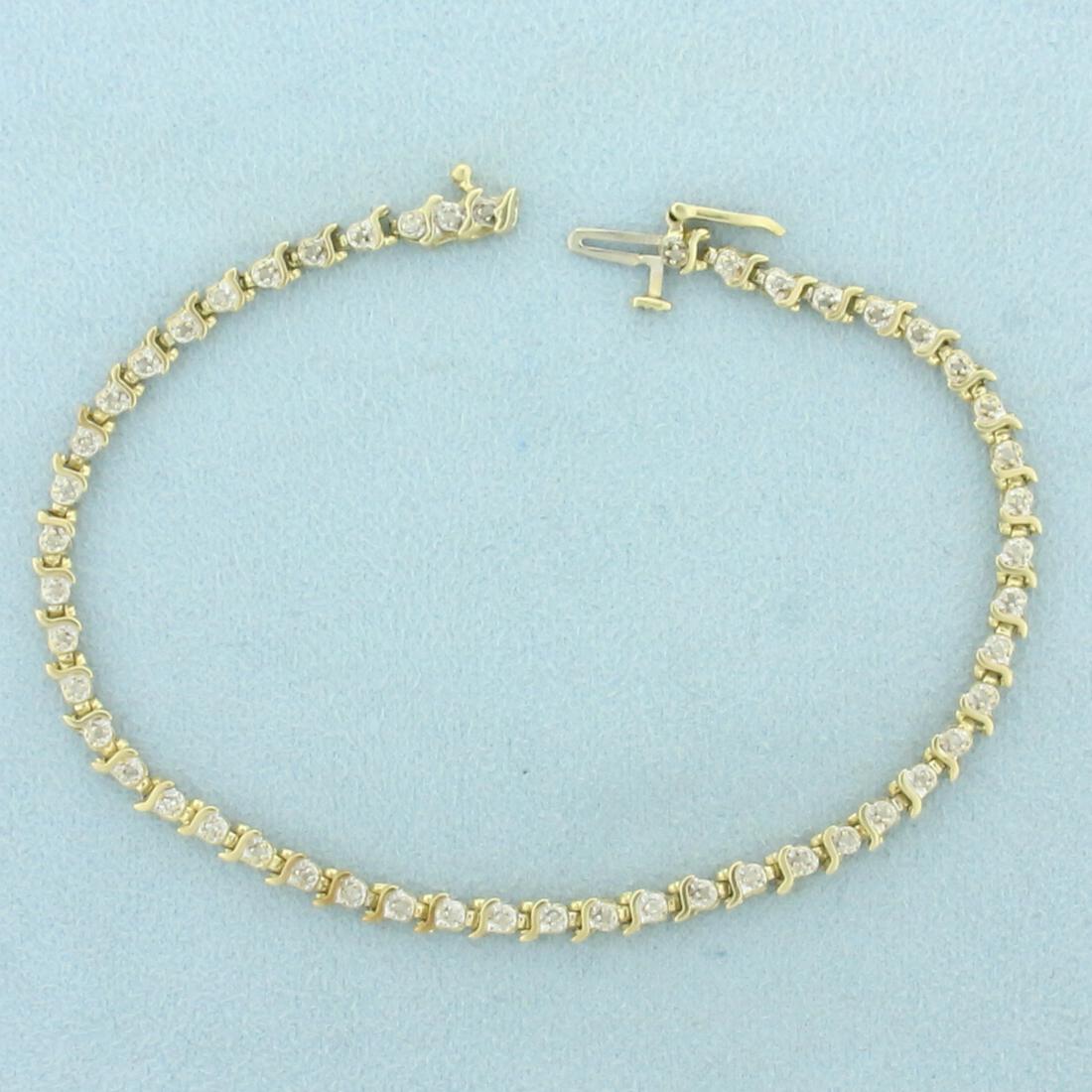 Diamond Tennis Bracelet in 10K Yellow Gold: In 10K Yellow Gold. Contains 50 high quality 1/2pt Diamonds. Safety clasp. 8 inches long. 3.3mm wide. 5.9g