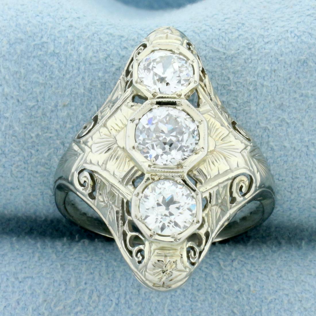 Antique Art Deco Edwardian Three-Stone Diamond Ring in: In 18K White Gold. Contains one .8ct High Quality Old European Cut Diamond, F color/I1 Clarity. Also contains two 1/2ct Old European Cut Diamonds, F color/SI clarity. Antique filigree mounting. Size 7