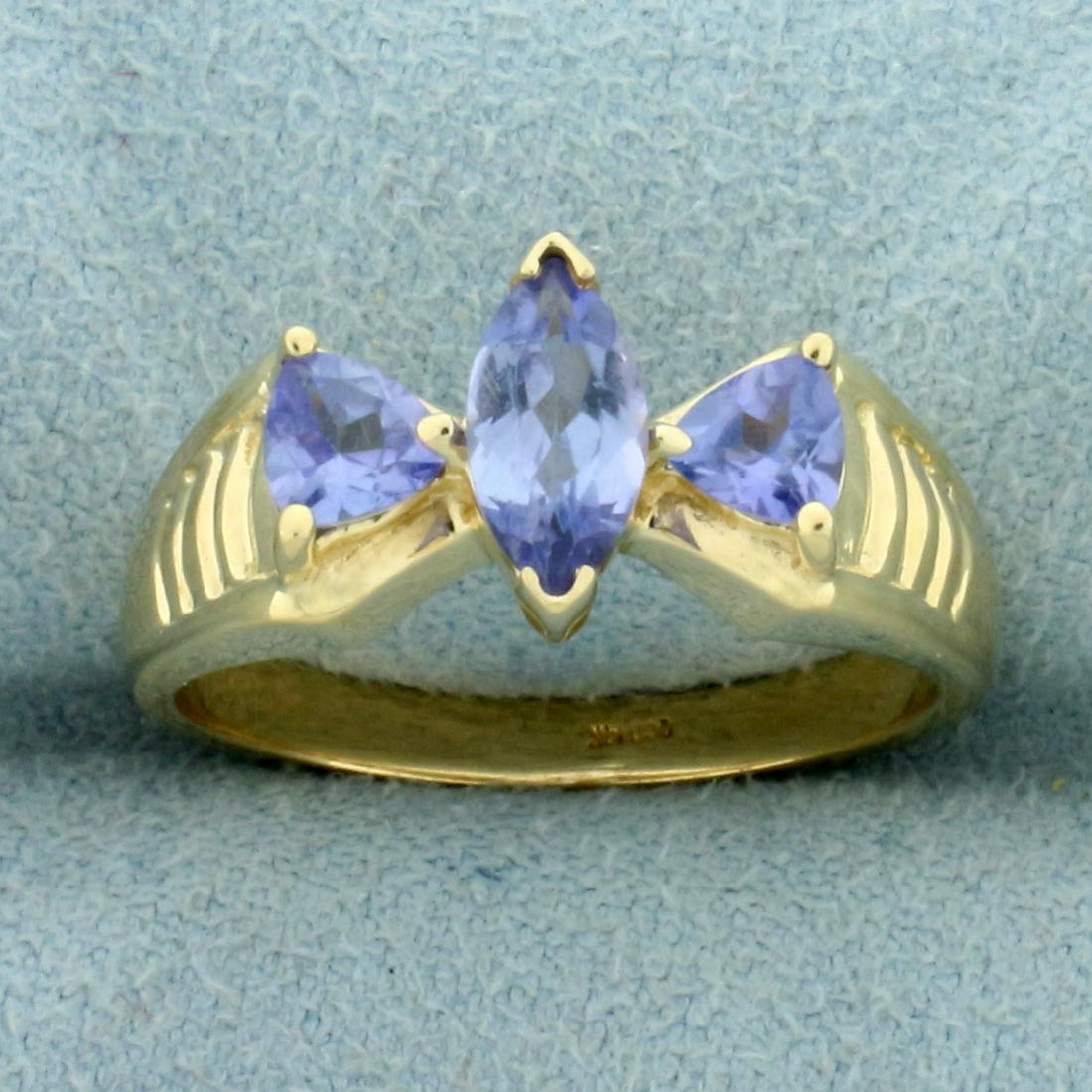 1.5ct TW Tanzanite Three-Stone Ring in 14K Yellow Gold: In 14K Yellow Gold. Contains one high quality natural 8x4mm marquise cut and two high quality natural 5mm trillion cut Tanzanite gemstones with bright purple color and excellent clarity. Size 8. 4.3g