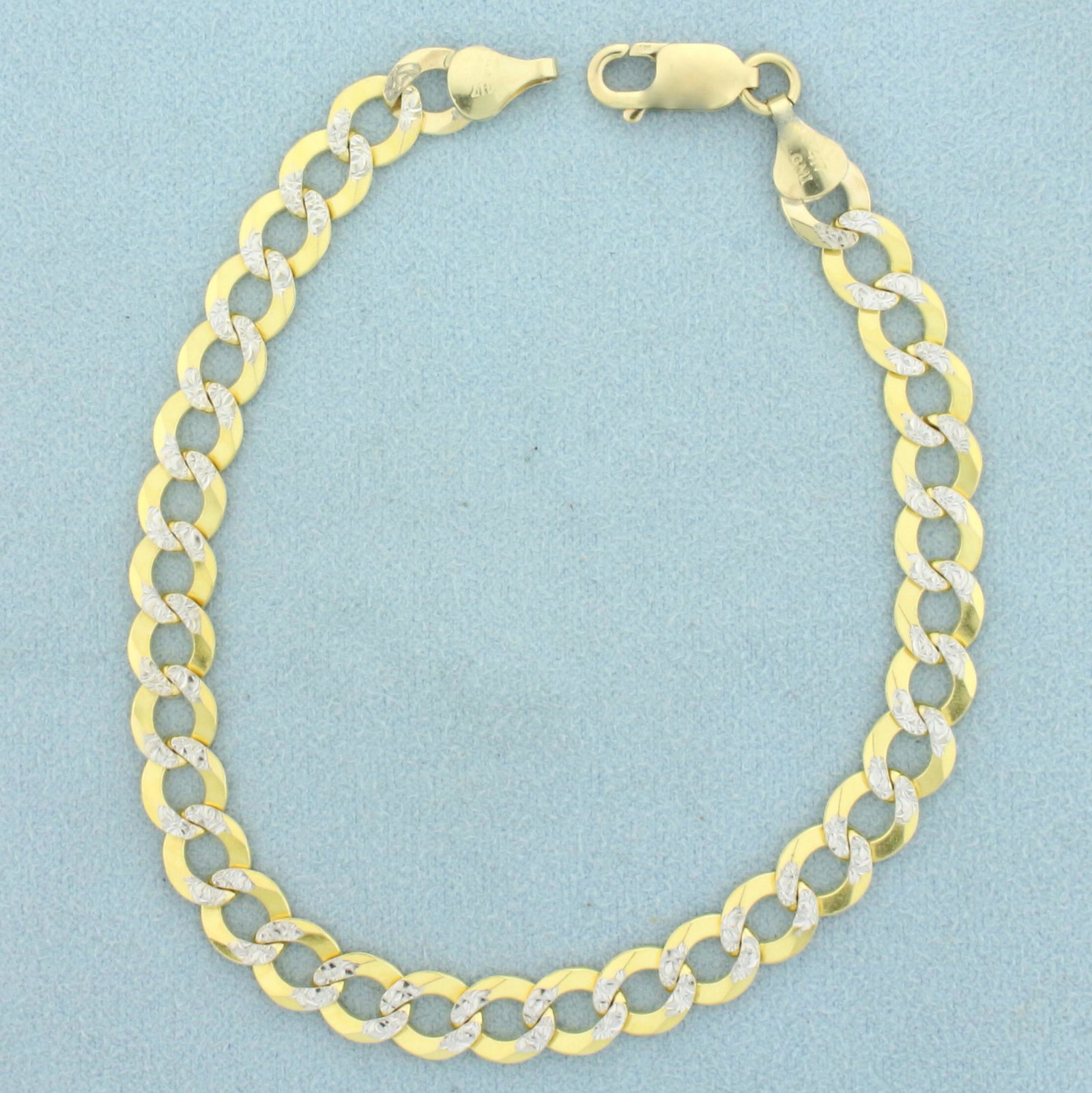 Mens 8 1/2 Inch Flat Curb Link Two-Tone Chain Bracelet: In 10K Yellow and White Gold. Lobster clasp. 8 1/2 inches long. 7mm wide. Diamond Cut and two-tone for very unique look. 10.0g