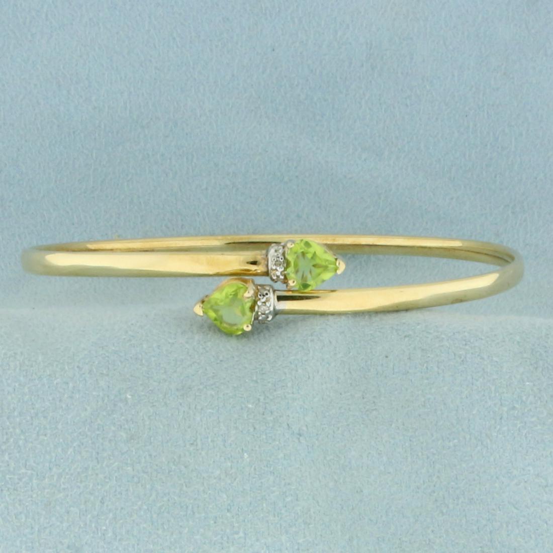 Peridot and Diamond Heart Bangle Bracelet in 14K Yellow: In 14K Yellow Gold. Contains two high quality natural 5.5mm heart cut Peridot gemstones with vibrant green color and excellent clarity. Also contains six high quality 1/2pt Diamonds. 2 1/2 inch diamet