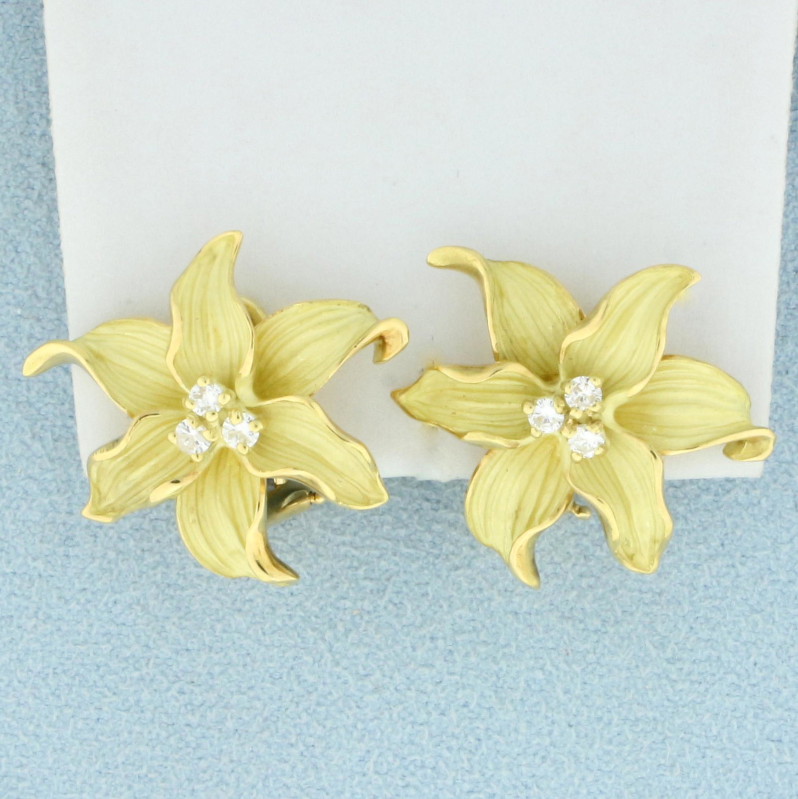 Designer Diamond Flower Earrings in 18K Yellow Gold: In 18K Yellow Gold. Contains six high quality Diamonds, 1/4ct TW, VS clarity/G color. Unique finish on flower leaves make them look more realistic. 7/8 inch long. Omega post backs for pierced ears. 11