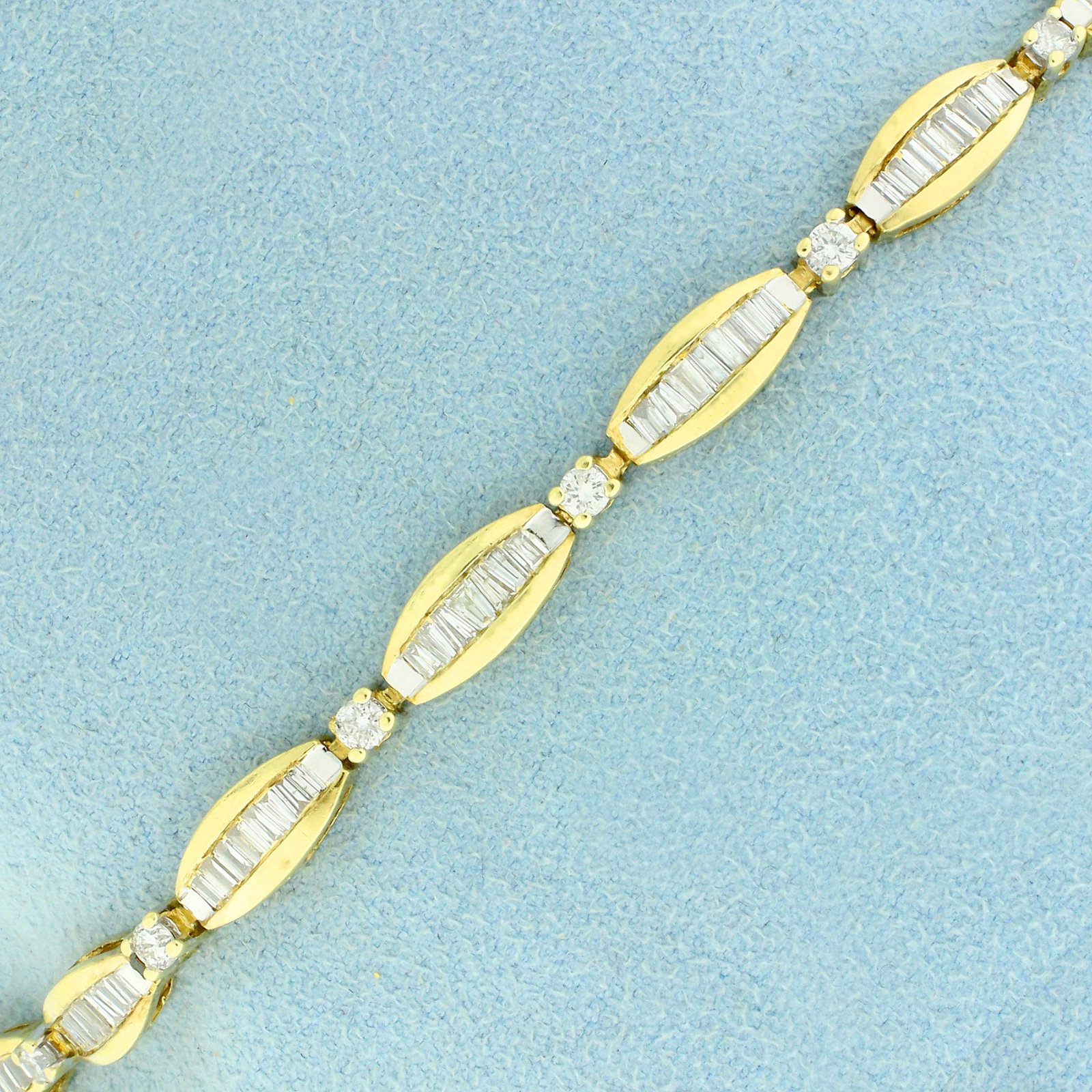 3ct TW Baguette and Round Diamond Line Bracelet in 14K: In 14K Yellow Gold. Contains 99 high quality baguette and eleven high quality .06ct round Diamonds, 3ct TW, SI clarity/H color. 7 inches long. 4.6mm wide. With safety clasp and safety chain. 10.6g