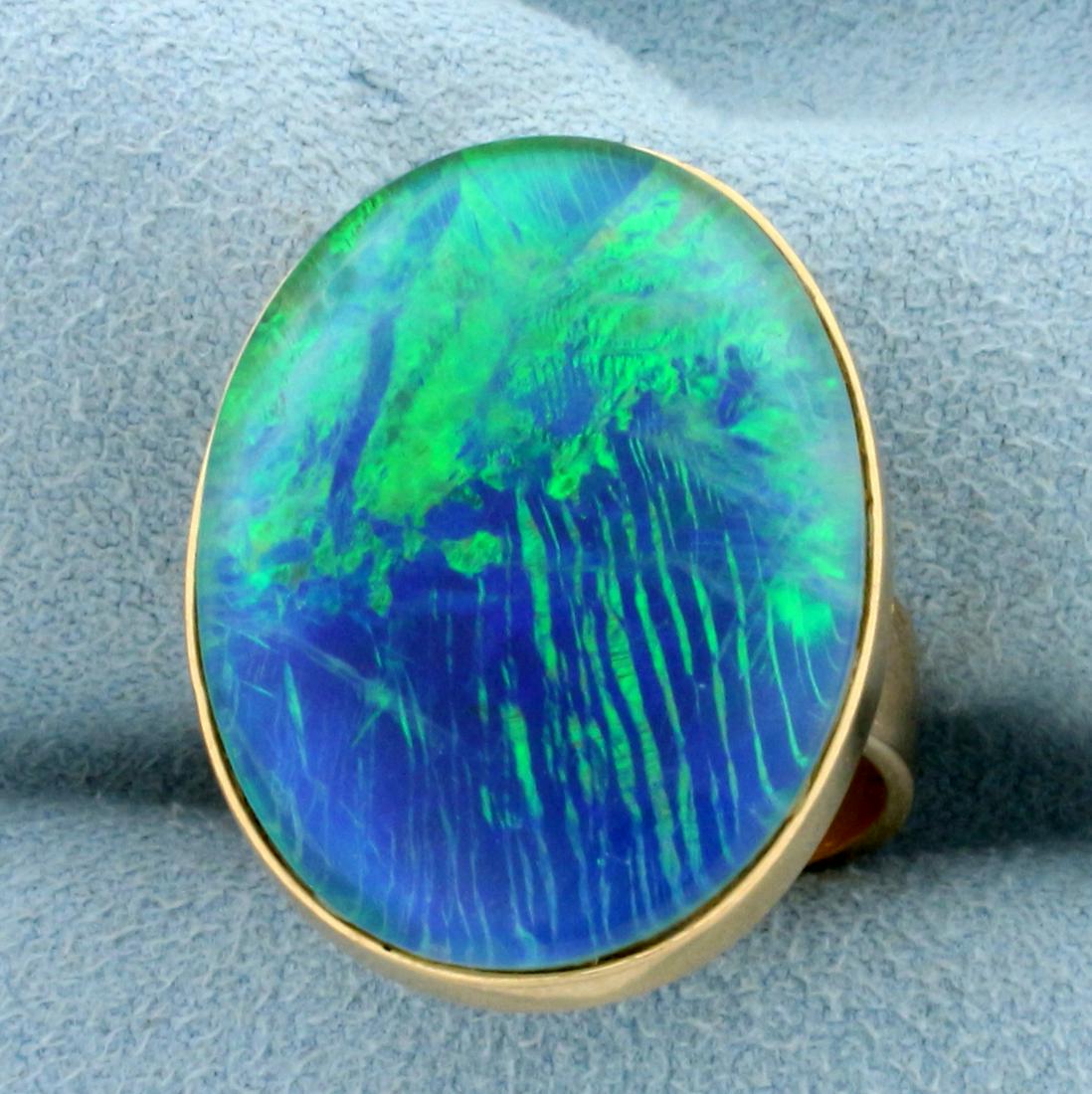 Large Black Opal Doublet Statement Ring in 18K Yellow: In 18K Yellow Gold with Rose Gold Undertone. Contains one high quality natural 25x20mm Doublet Black Opal gemstone with intense flashes of green and blue. Size 5.5. 11.6g