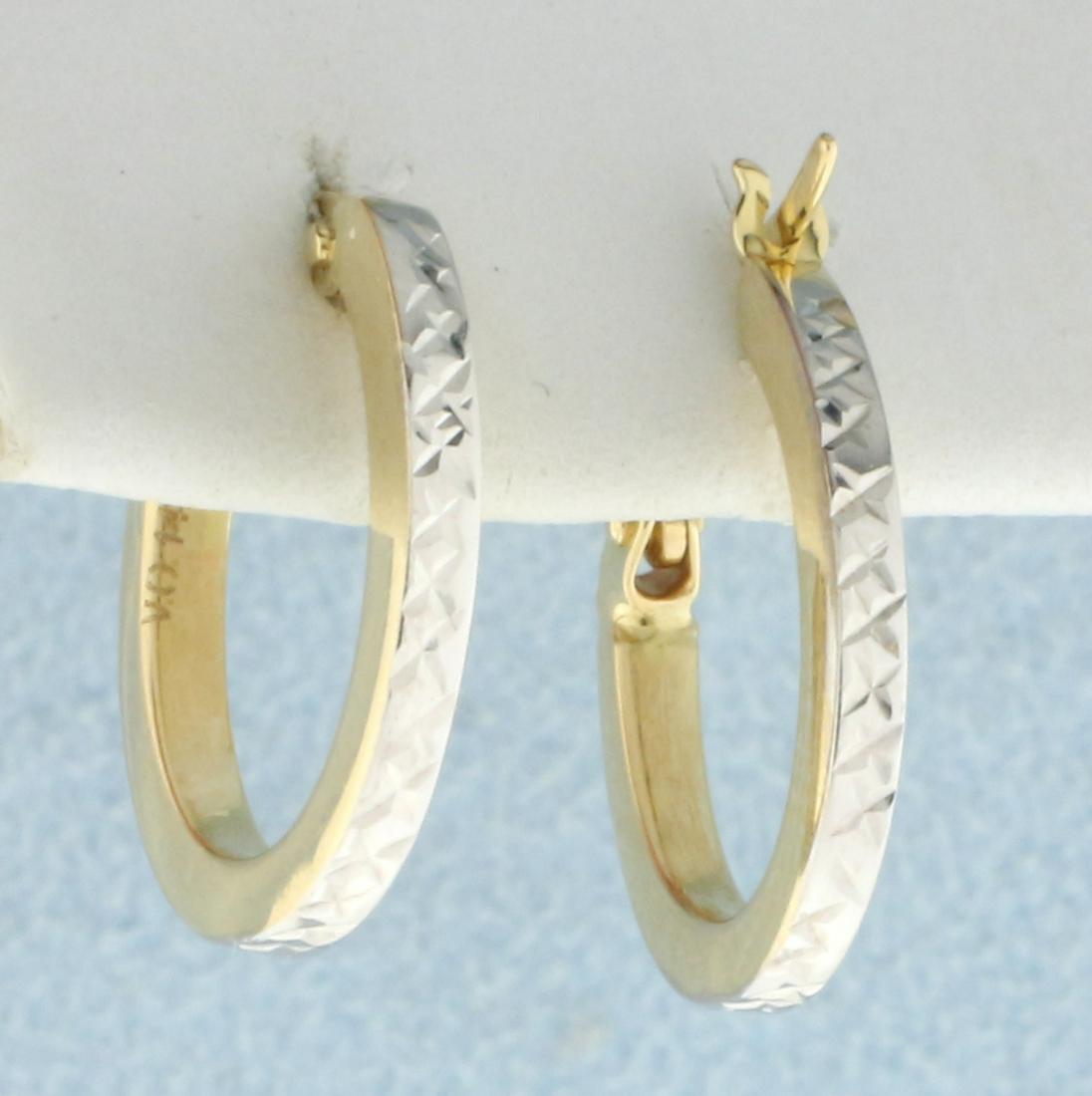 Diamond Cut Two Tone Hoop Earrings in 14K Yellow and: In 14K Yellow and White Gold. Diamond cut for extra sparkle. 5/8 inch long, 1.8mm wide. 1.2g.