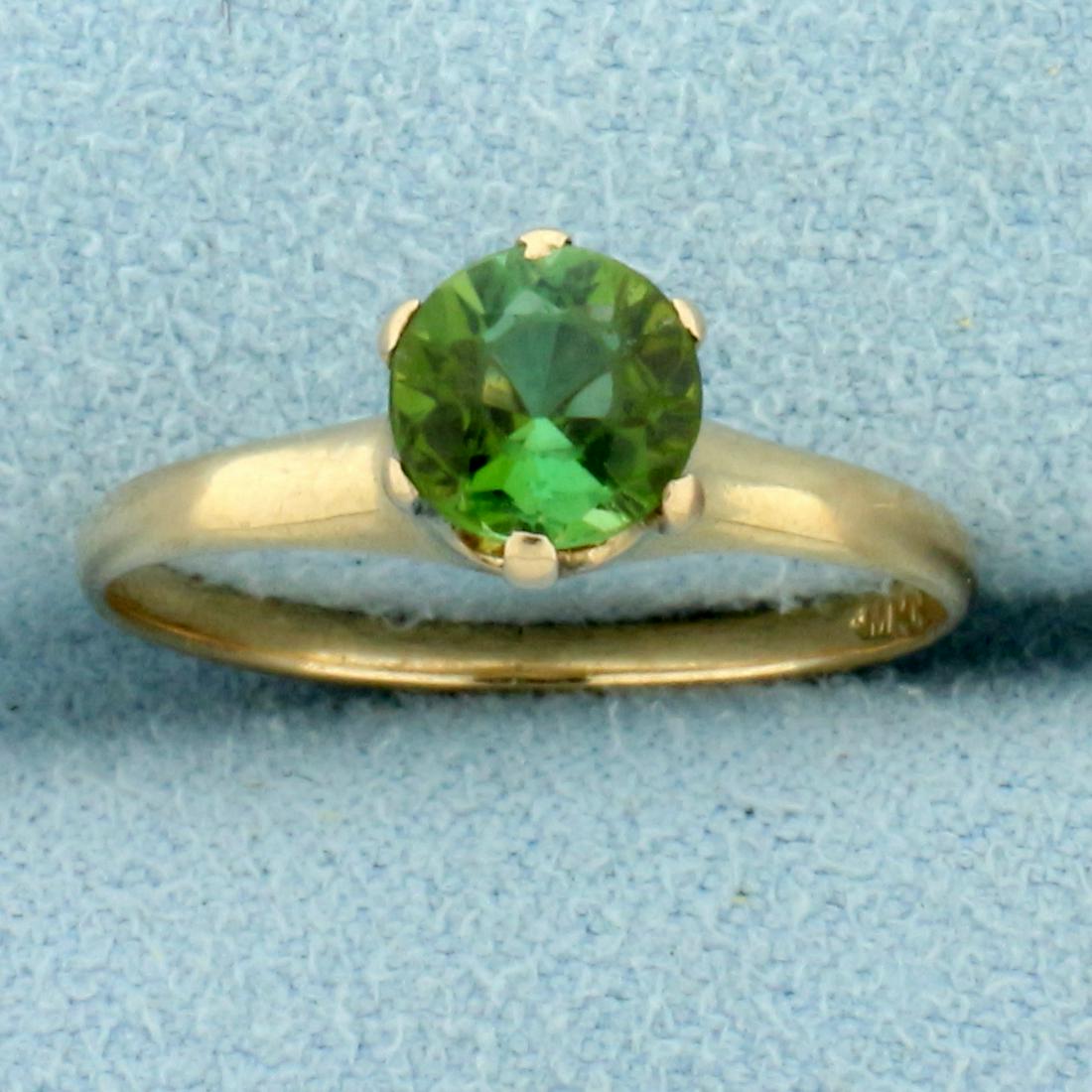 Green Garnet Solitaire Ring in 10K Yellow Gold: In 10K Yellow Gold. Contains one high quality natural 6mm round Green Garnet gemstone with intense green color and excellent clarity. Size 5 1/2. 1.6g.
