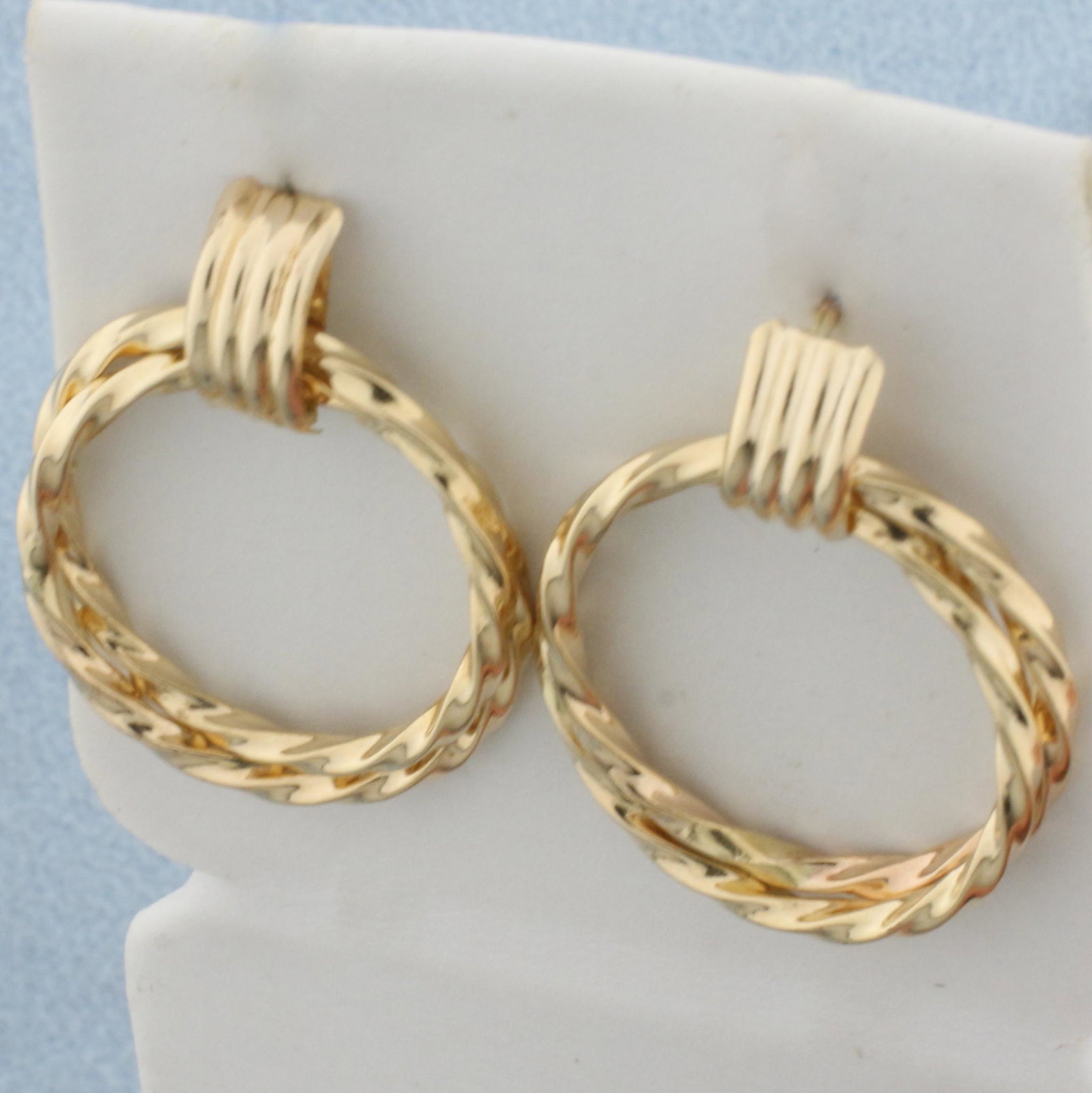 Double Hoop Twisting Design Earrings in 14K Yellow Gold: In 14K Yellow Gold. 1 inch diameter. With friction backs. 2.3g.