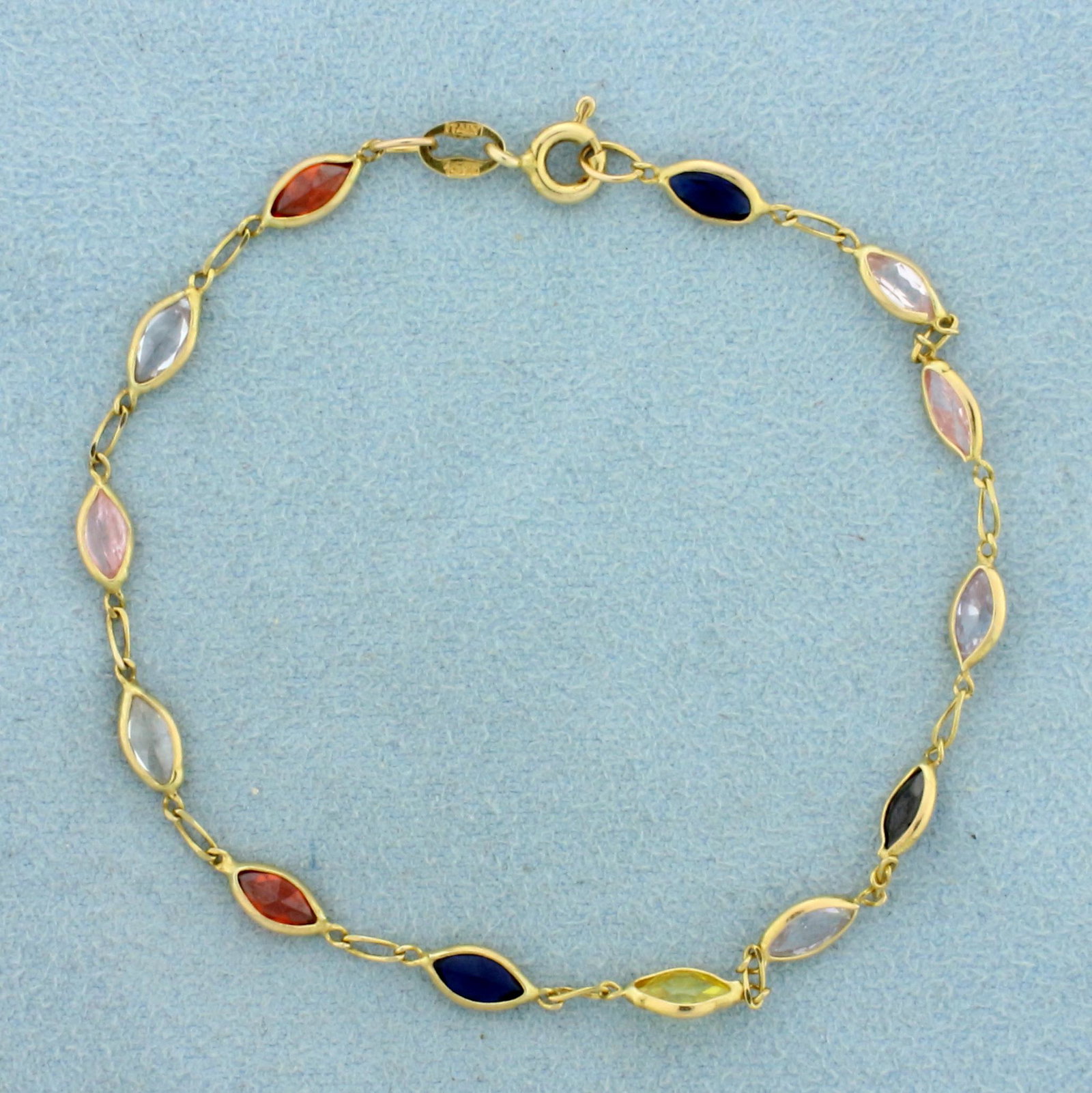 7 Inch Rainbow Topaz Gemstone Bracelet in 14K Yellow: In 14K Yellow Gold. Contains thirteen high quality 6mm marquise cut Topaz gemstones in different vibrant colors and excellent clarity. 7 inches long. 4mm wide. 2.7g