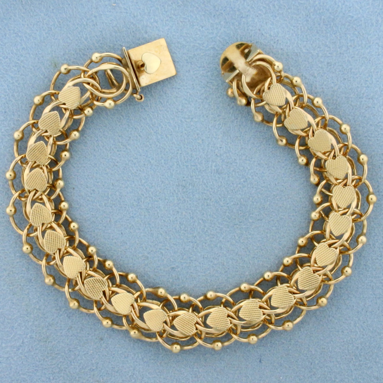 Designer Heart Link Charm Bracelet in 14K Yellow Gold: In 14K Yellow Gold. 7 inches long, 13.5mm wide. With safety clasp. 23.7g