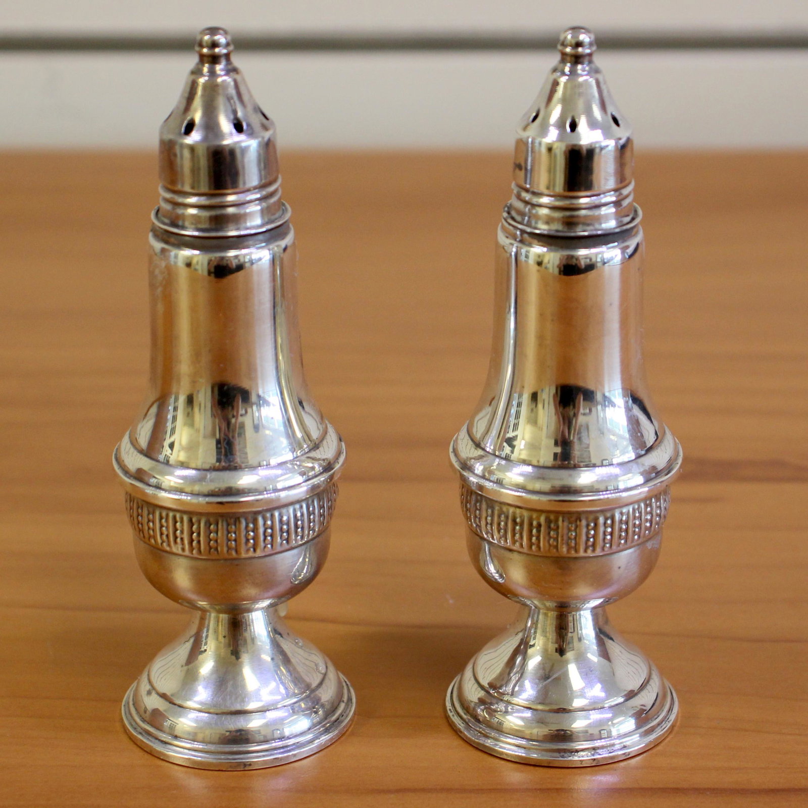 AMC Sterling Silver Salt and Pepper Shakers: In Sterling Silver, weighted. Salt and pepper shakers set. 5 inches high, 1 1/4 inches wide. 276.4g.