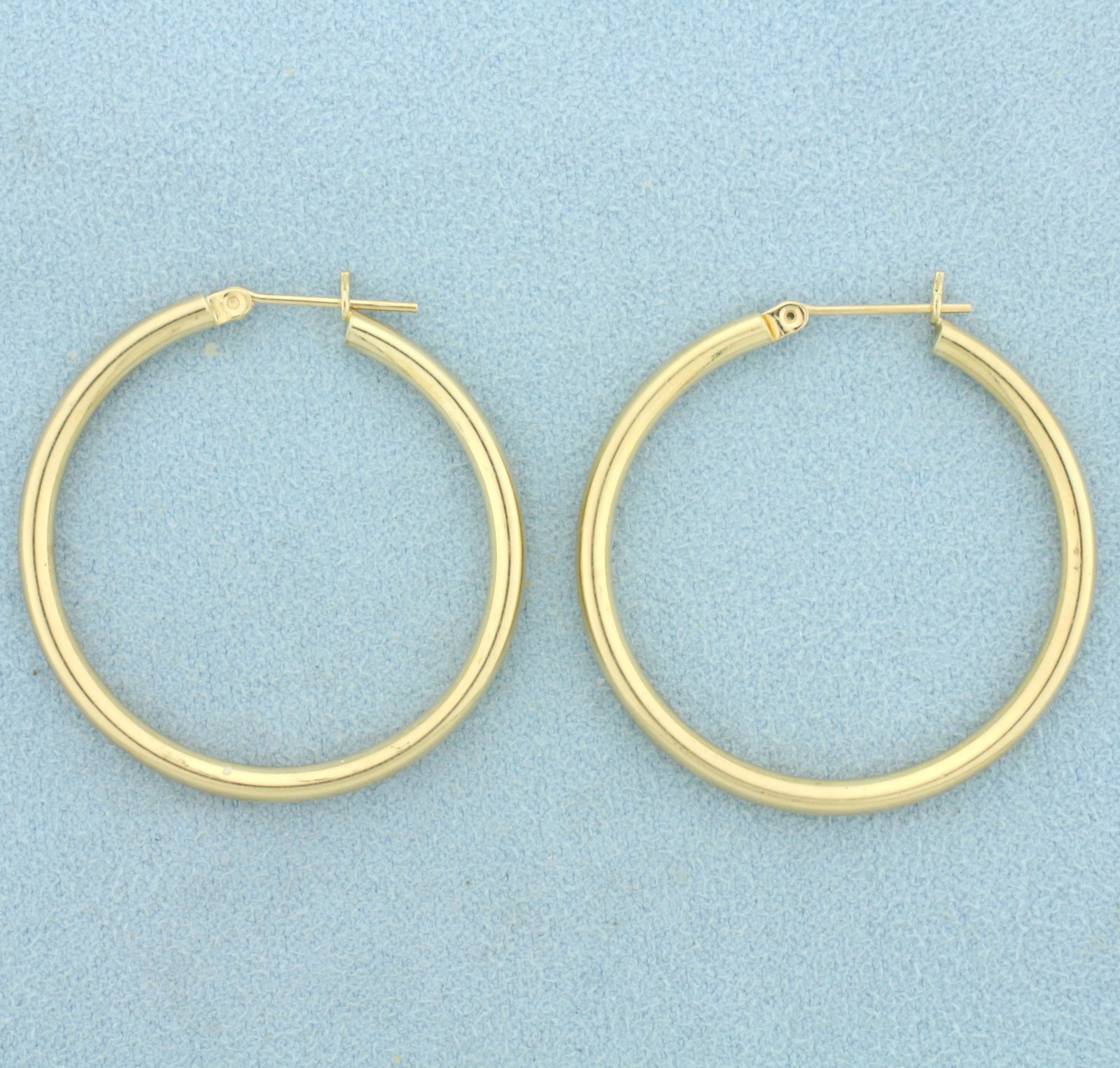 Gold Hoop Earrings in 14K Yellow Gold: In 14K Yellow Gold. 1 3/8 inches long, 2.5mm wide. 2.4g.