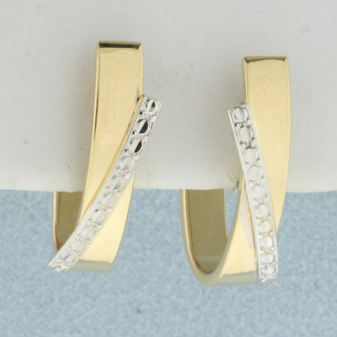 Two Tone Designer Hoop Earrings in 14K Yellow and White: In 14K Yellow and White Gold. 3/4 inch long. 3.8mm wide. Unique design looks like diamond earrings without the diamonds. 1.8g