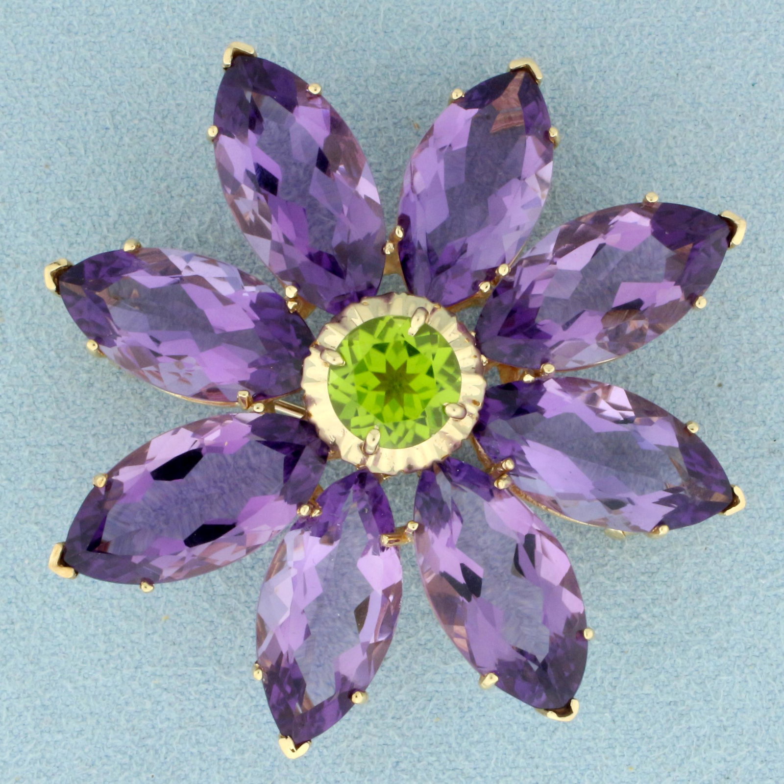 Large Amethyst and Peridot Flower Brooch Pin in 14K: In 14K Yellow Gold. Contains eight high quality natural 19x10mm marquise cut Amethyst gemstones with intense purple color and excellent clarity. Also contains one 9mm high quality natural round Perido