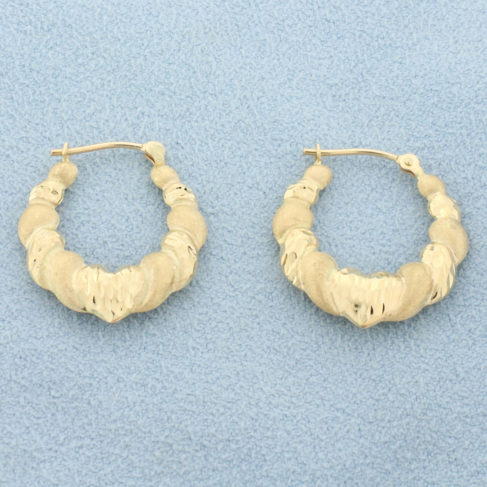 Diamond Cut Heart Hoop Earrings in 14K Yellow Gold: In 14K Yellow Gold. 7/8 inch long. 1.4g.