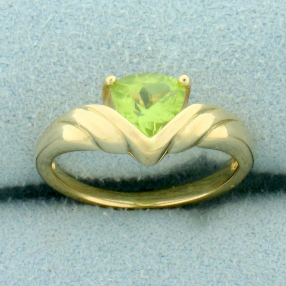 Peridot Solitaire Ring in 14K Yellow Gold: In 14K Yellow Gold. Contains one high quality natural 6mm trillion cut Peridot gemstone with vibrant color and excellent clarity. Size 4 1/2. 2.9g.