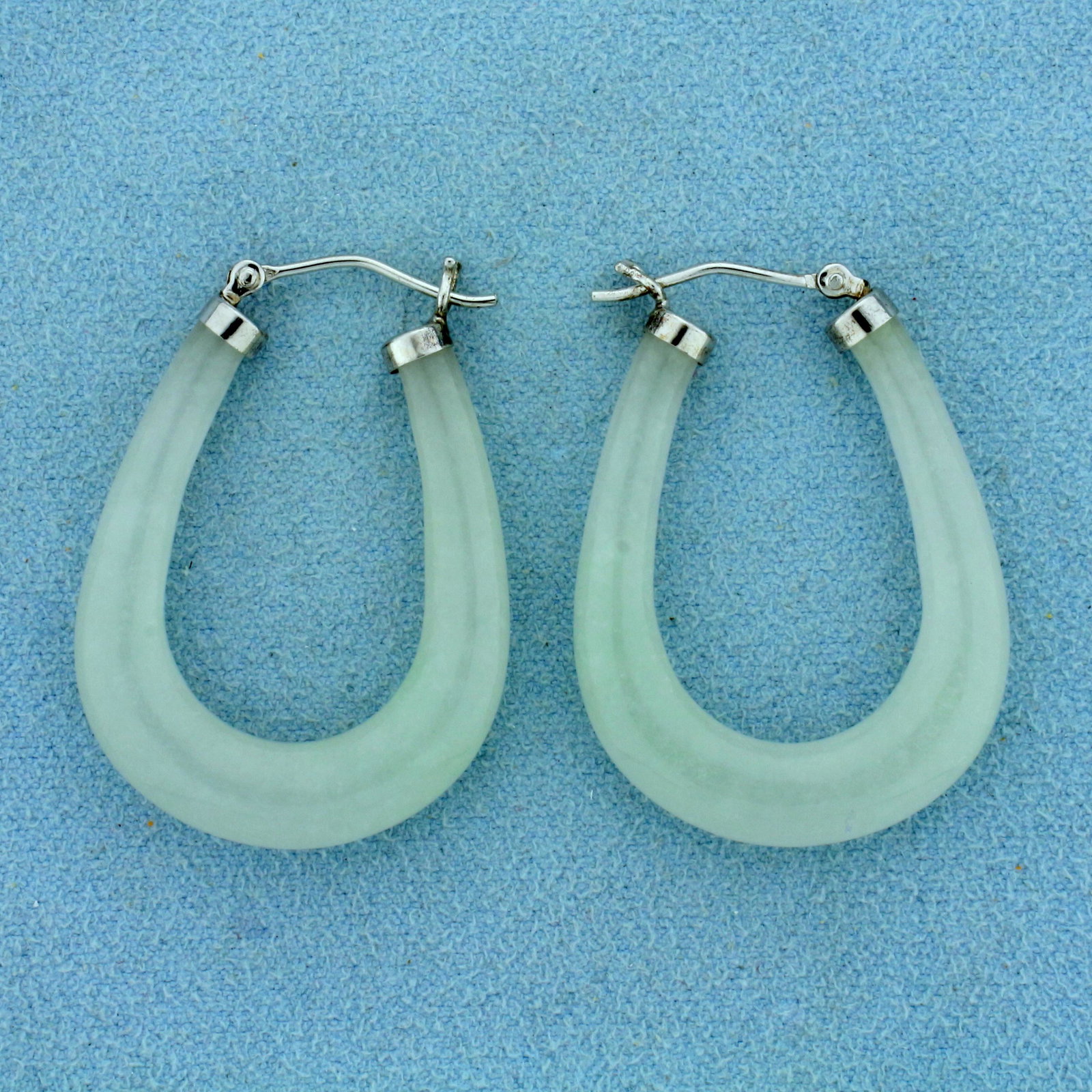 White Jade Elongated Hoop Earrings in Sterling Silver: In Sterling Silver. 1 1/2 inches long. 5mm wide. Jade is beautiful white color with hint of green. 10.0g