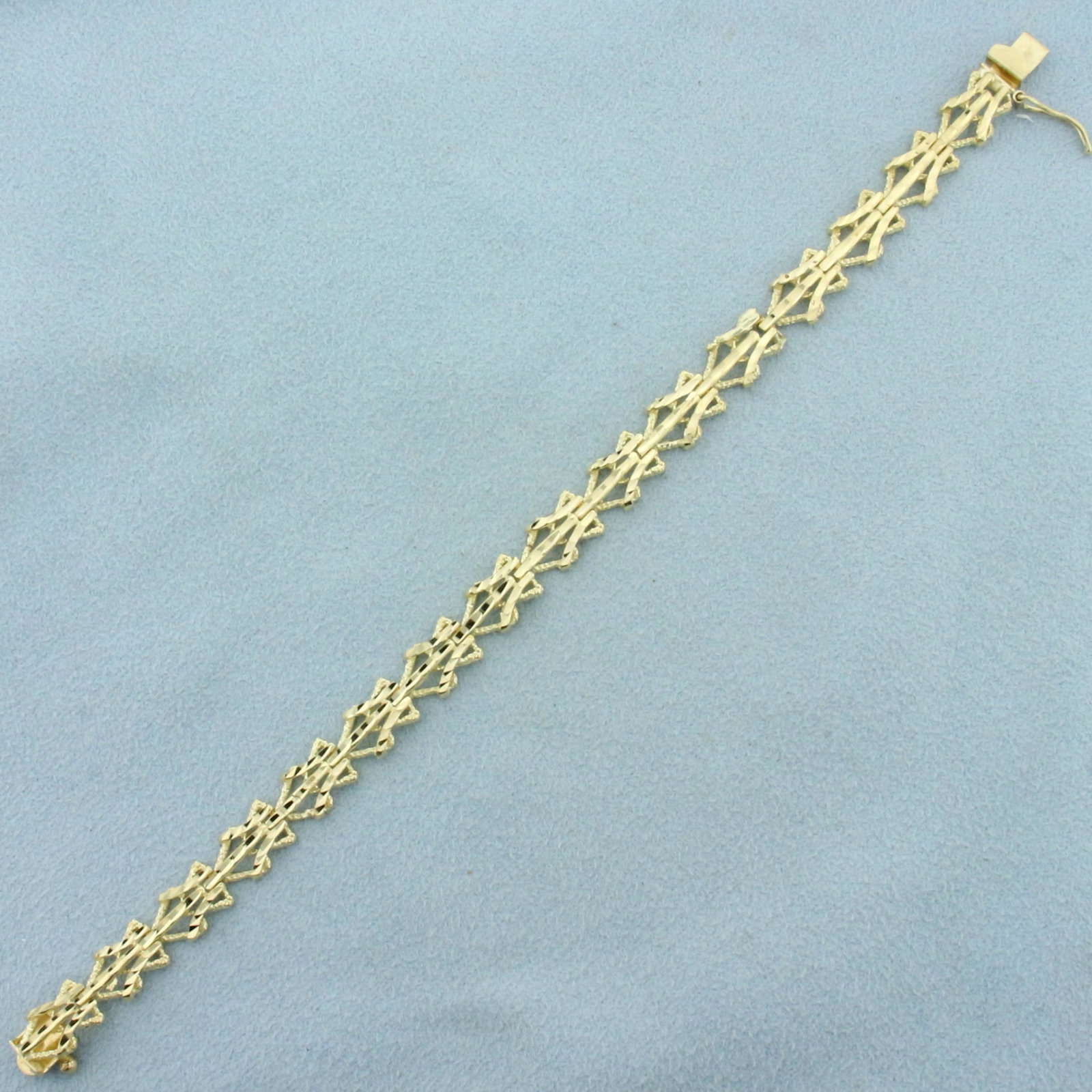 Diamond Cut Designer Triangle Link Bracelet in 10K: In 10K Yellow Gold. Safety clasp. 6 3/4 inches long. 7.5mm wide. 8.4g