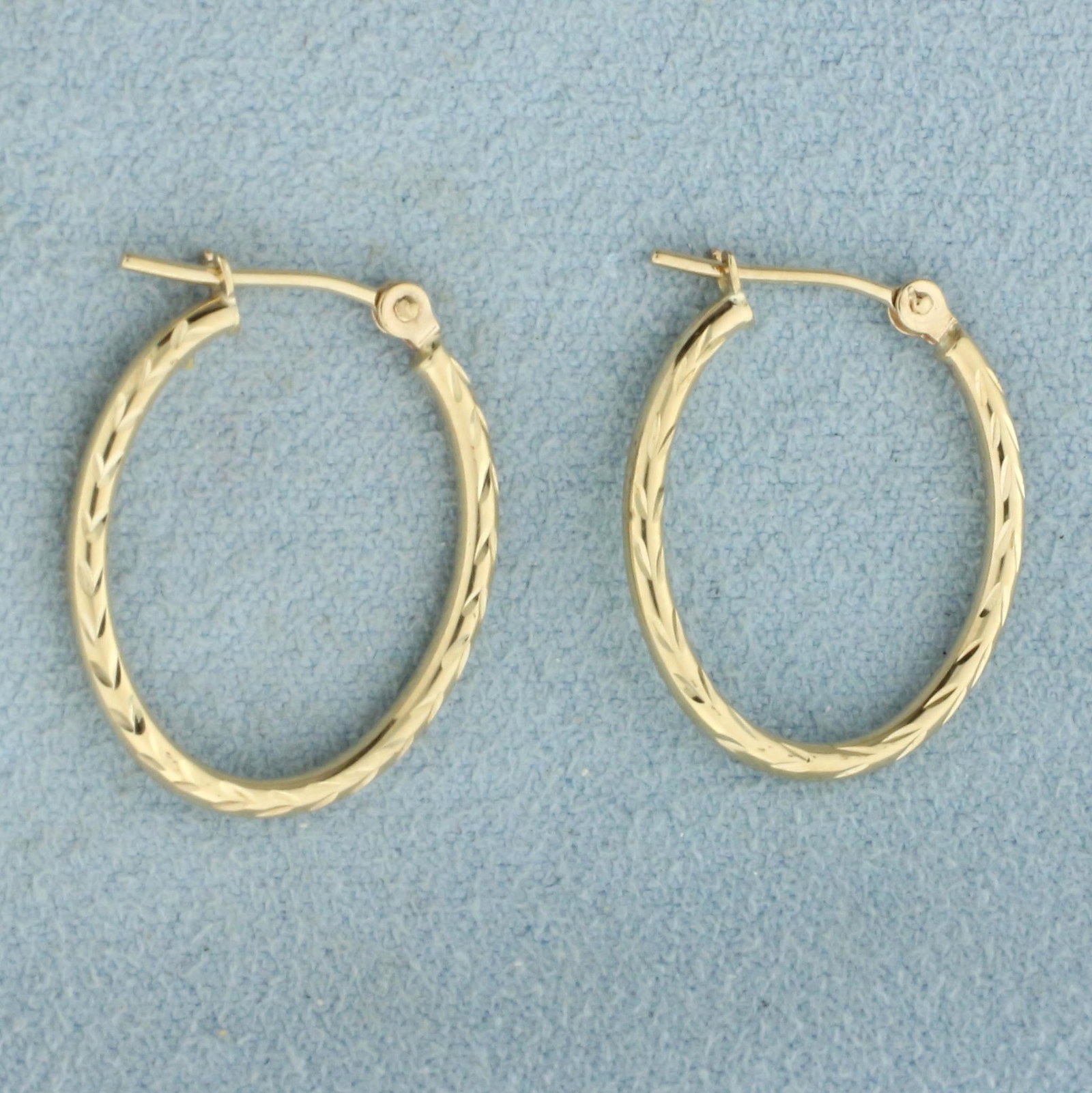 Diamond Cut Oval Hoop Earrings in 10k Yellow Gold: In 10k Yellow Gold. 7/8 inch long. .7g.