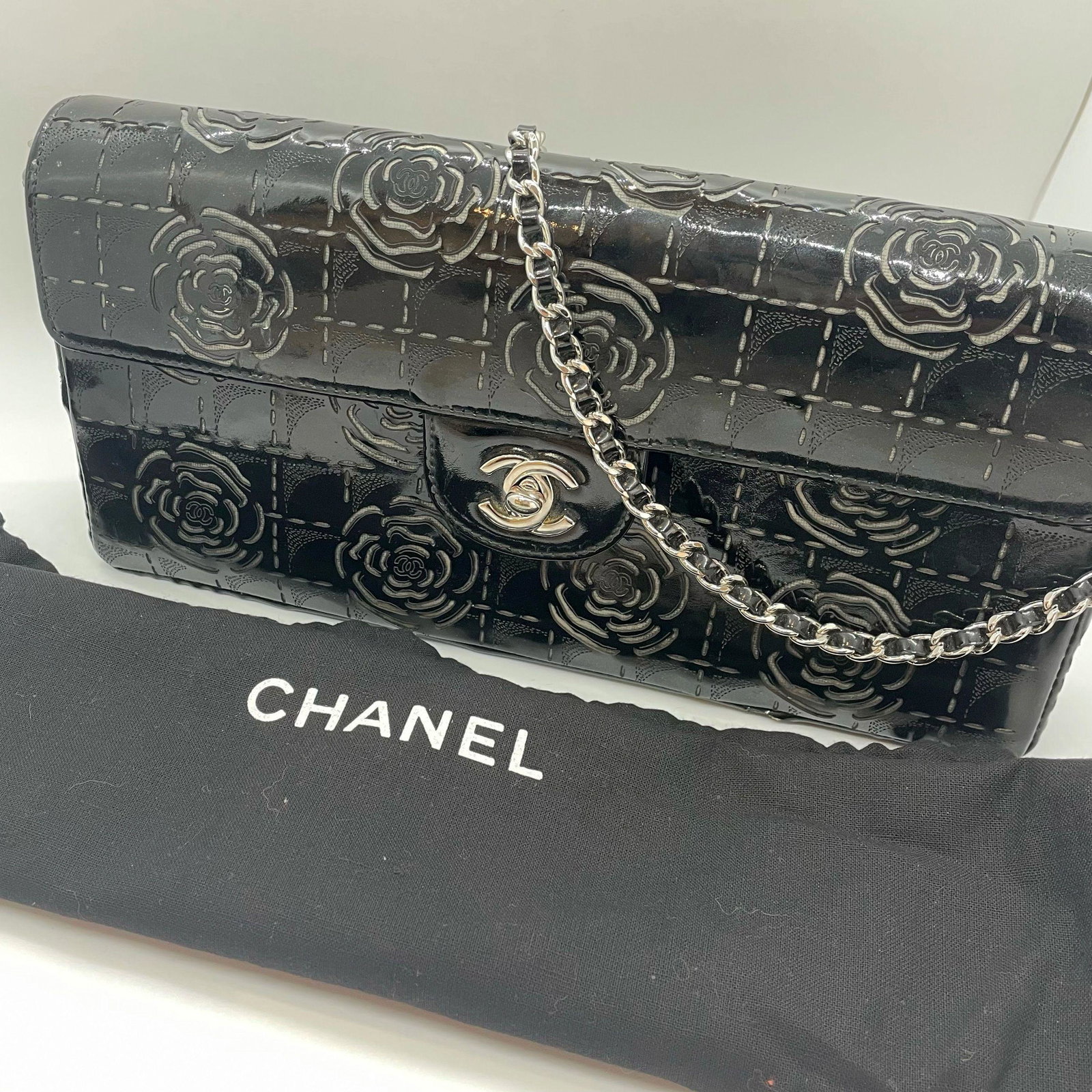 Authentic Chanel 3-Way Flap Bag Black Patent Camellia: Guaranteed authentic with serial number sticker and dust bag. In excellent condition with very little wear. Sat unused for most of its life. Meticulous laser cut camellia flower design with signature 