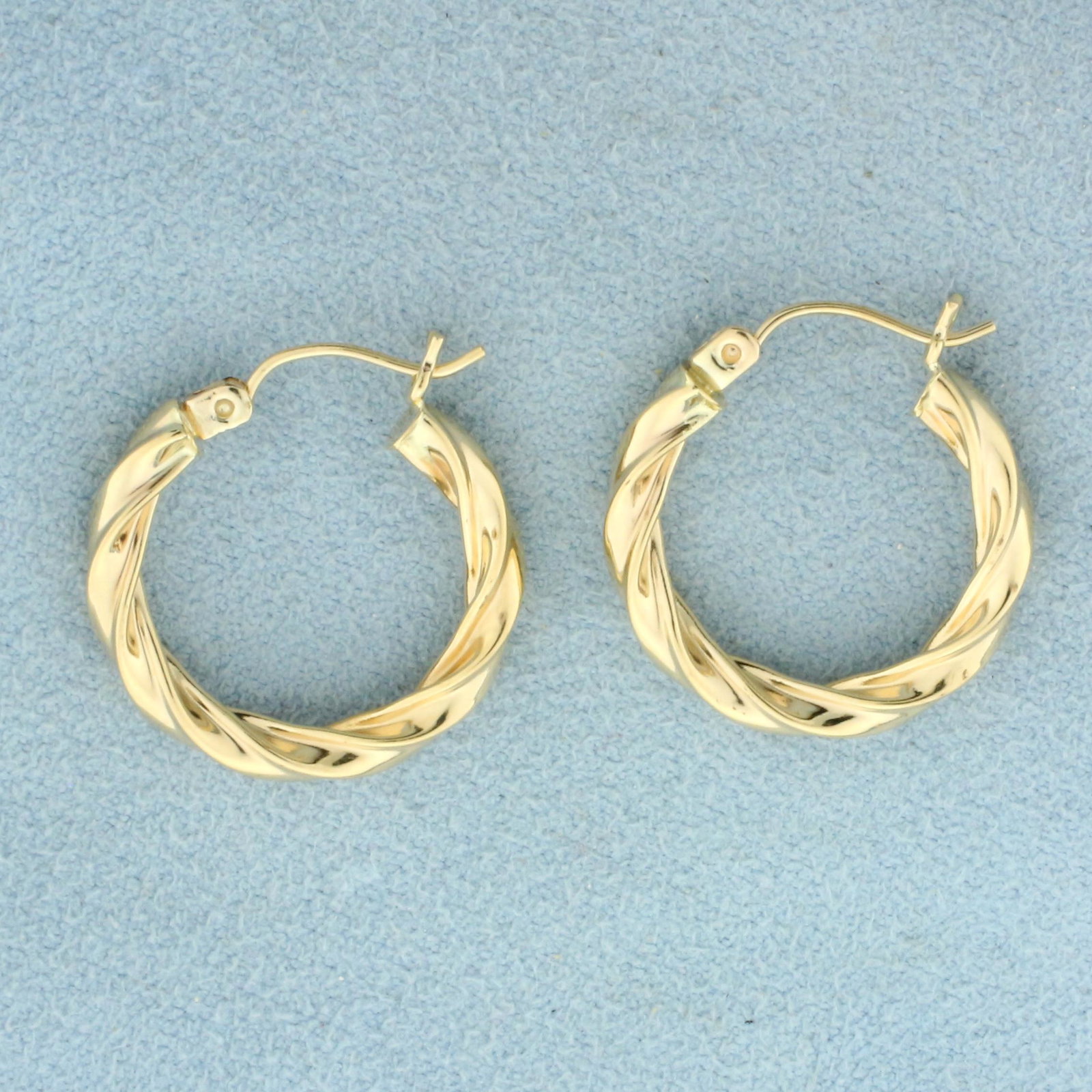 Twisting Design Hoop Earrings in 14k Yellow Gold: In 14k Yellow Gold. 7/8 inch diameter. 1.9g.