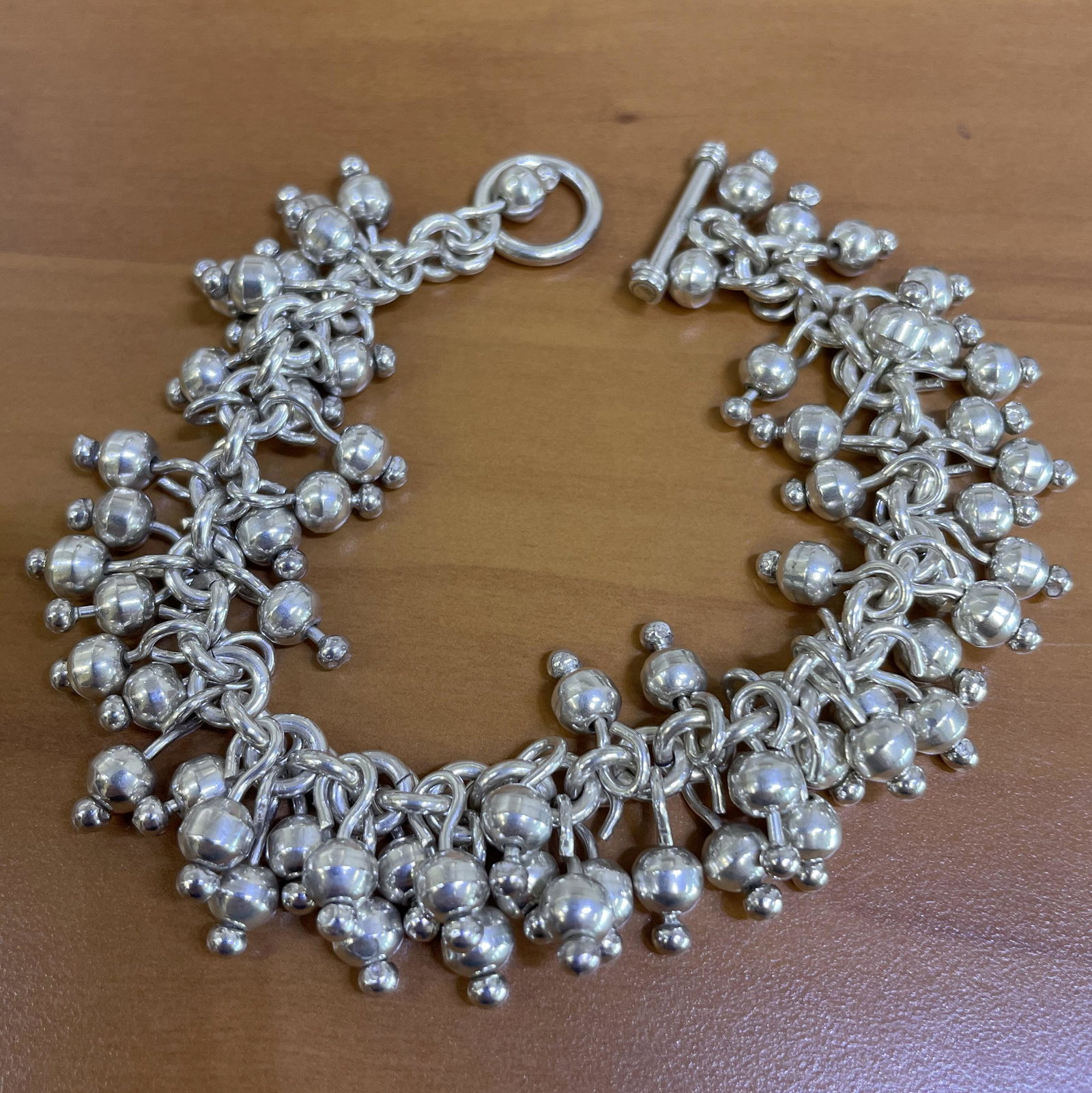 Dangle Beaded Bracelet in Sterling Silver: In .925 sterling silver. Measures 7 1/2 inches long, 1 1/4 inches wide. 73.8g