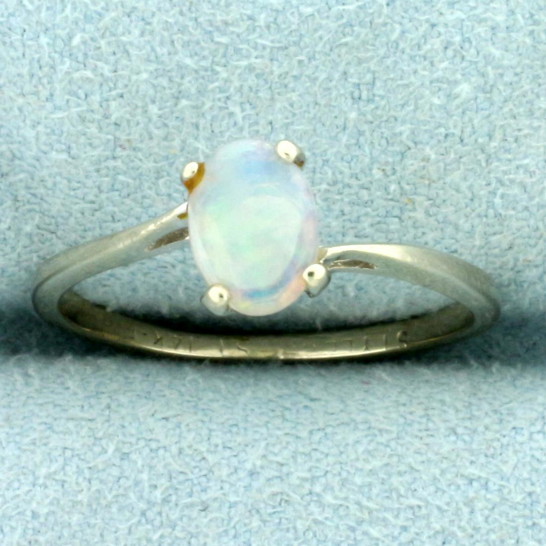 Opal Solitaire Ring in 14K White Gold: In 14K White Gold. Contains one high quality natural 7mm oval Opal gemstone with flashes of green, purple, and blue. Size 7. 1.7g.