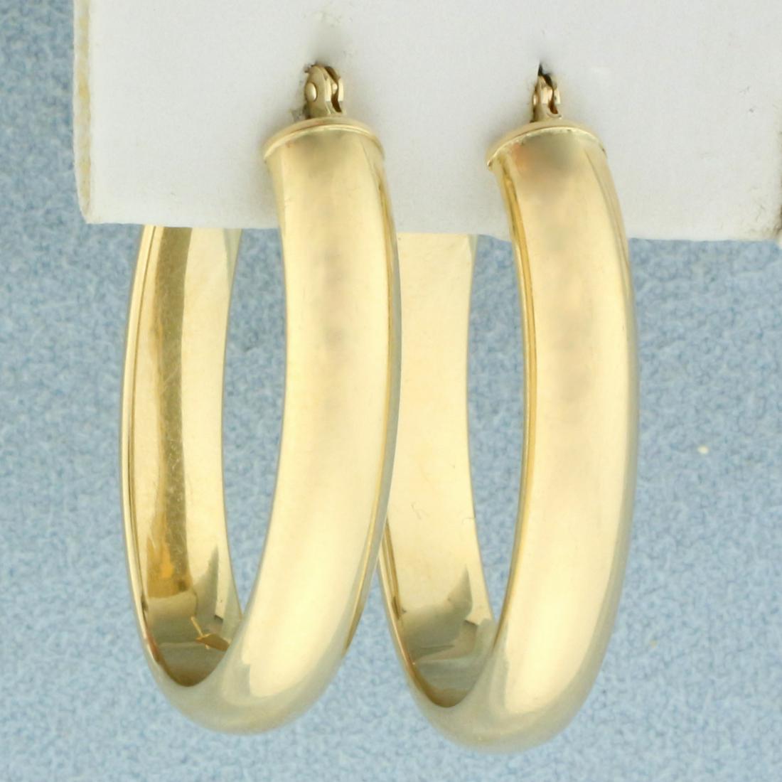 Wide Hoop Earrings in 14K Yellow Gold: In 14K Yellow Gold. 1 1/4 inches long, 5mm wide. 2.1g.