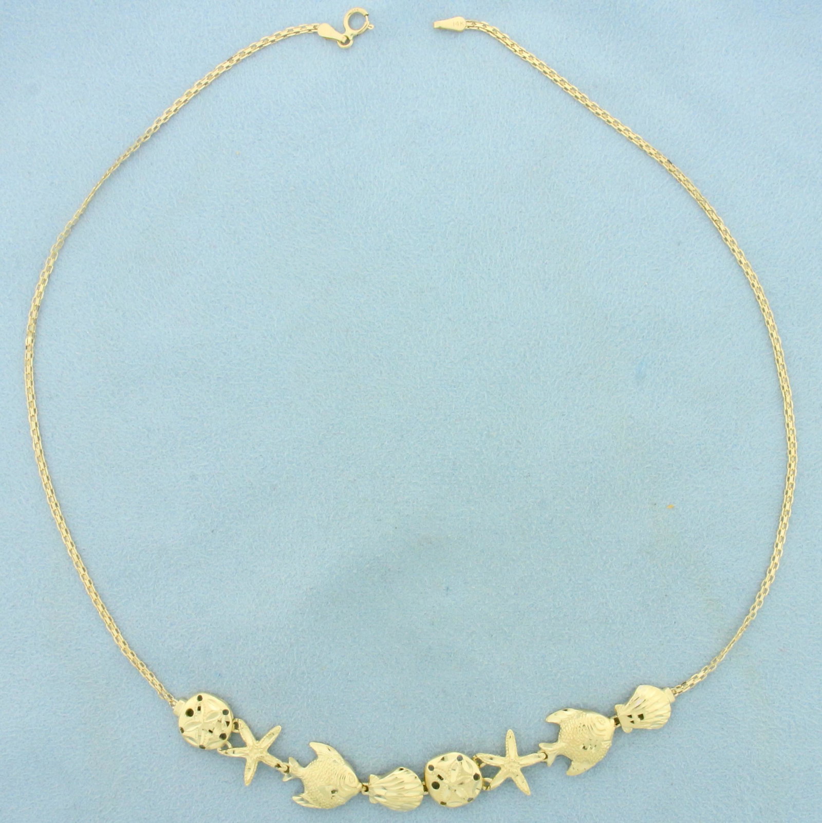 Sea Life Star Fish Sand Dollar Fish Seashell Necklace: In 14K Yellow Gold. 16 3/4 inches long. Chain is 1.6mm wide. Sea life is 12 to 14mm long. 8.2g