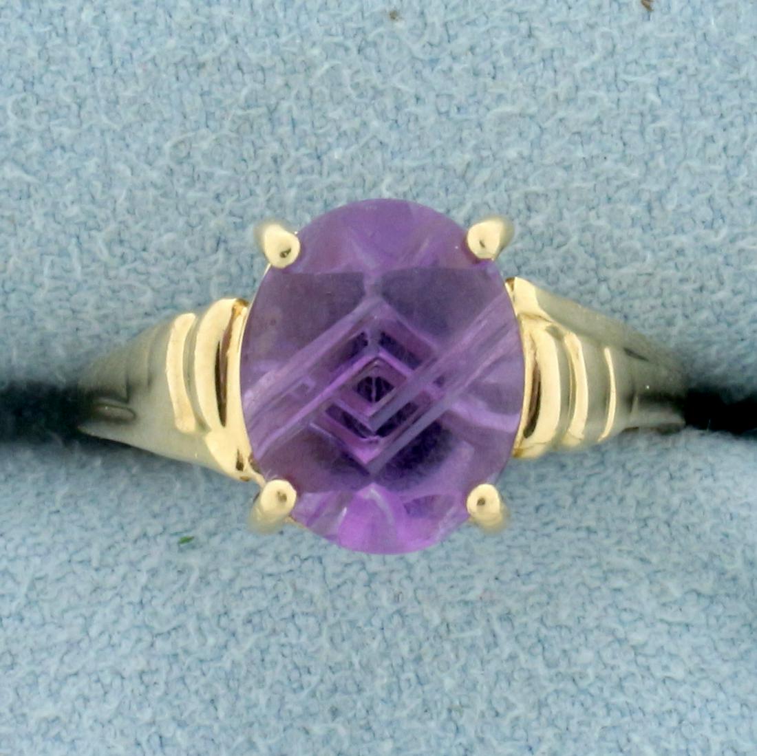 Unique Etched 3ct Amethyst Solitaire Ring in 14K Yellow: In 14K Yellow Gold. Contains one high quality natural 10x8mm oval cabochon Amethyst gemstone with pastel purple color and excellent clarity. Gemstone is etched on back for unique design. Size 6. 3.2g