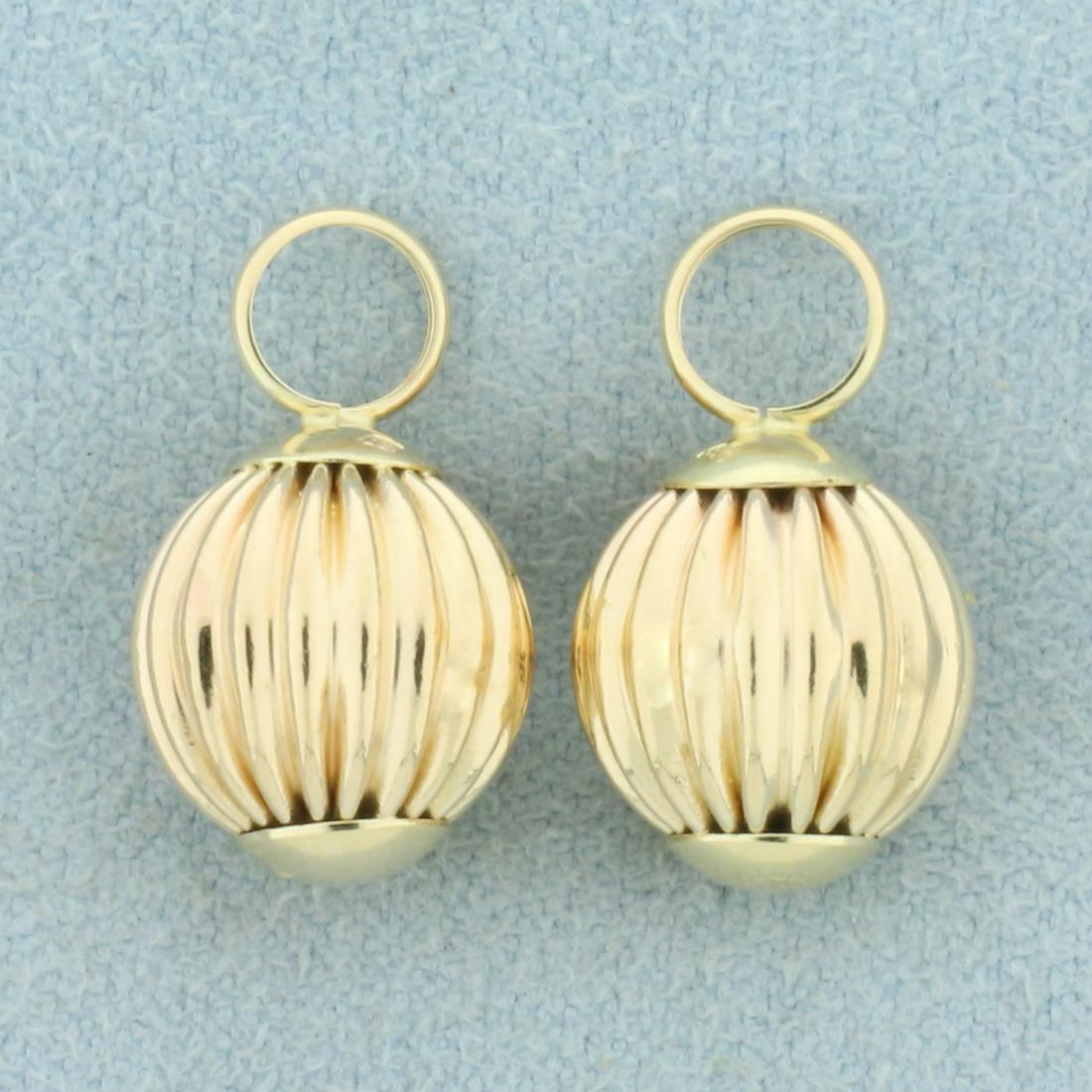 Hoop Earing Enhancers in 14k Yellow Gold: In 14k yellow gold. Can accommodate up to 4mm tube hoops. 5/8 inch long. 1.0g.