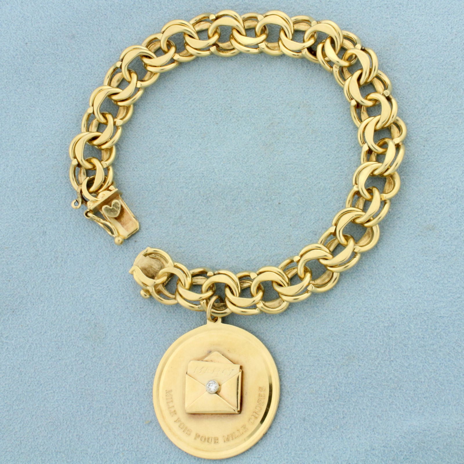 Vintage French Medallion Charm Bracelet in 14k Yellow: In 14k yellow gold. Charm contains one .05ct high quality diamond, VS clarity/F color. Reads "MERCI" and "MILLIE FOIS POUR MILLLIE CHOSES" (translates to - "Thank you a thousand times for a thousand t