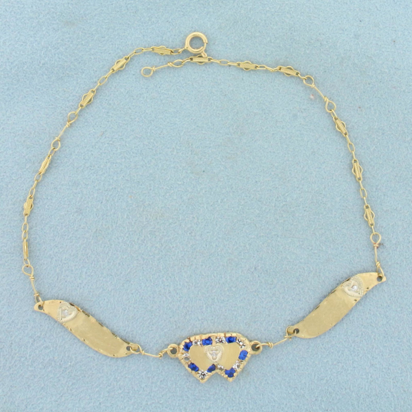 Vintage Diamond and Sapphire Heart Chain Bracelet in 14y Yellow Gold: In 14k yellow gold. Contains three high quality 1/2pt diamonds. Also contains fourteen 2mm white and blue sapphire gemstones with vibrant color and excellent clarity. 9 inches long. 3.4g