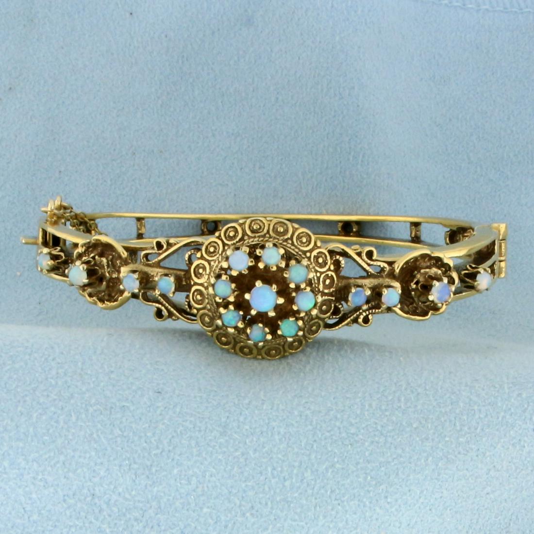 Vintage Opal Bangle Bracelet in 14K Yellow Gold: In 14K Yellow Gold. Contains seventeen high quality natural Opal gemstones from 2.5 to 3mm each, with flashes of green, blue, and purple. 2 1/4 inch diameter. With safety chain. 23.5g