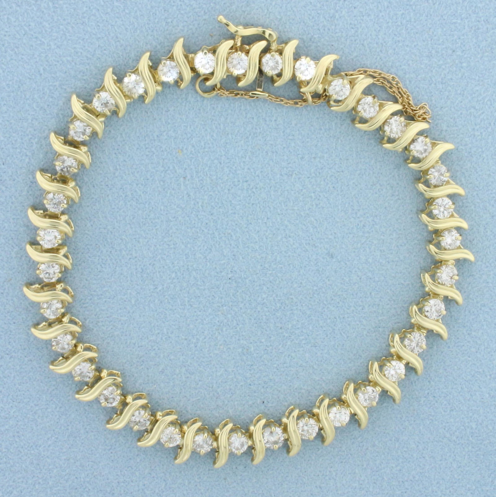 5ct Diamond Tennis Bracelet in 14k Yellow Gold: 14k yellow gold. Contains 35 high quality round brilliant diamonds, 5ct TW, I color/I1 clarity. 8 inches long. Safety clasp with safety chain. 14.3g.