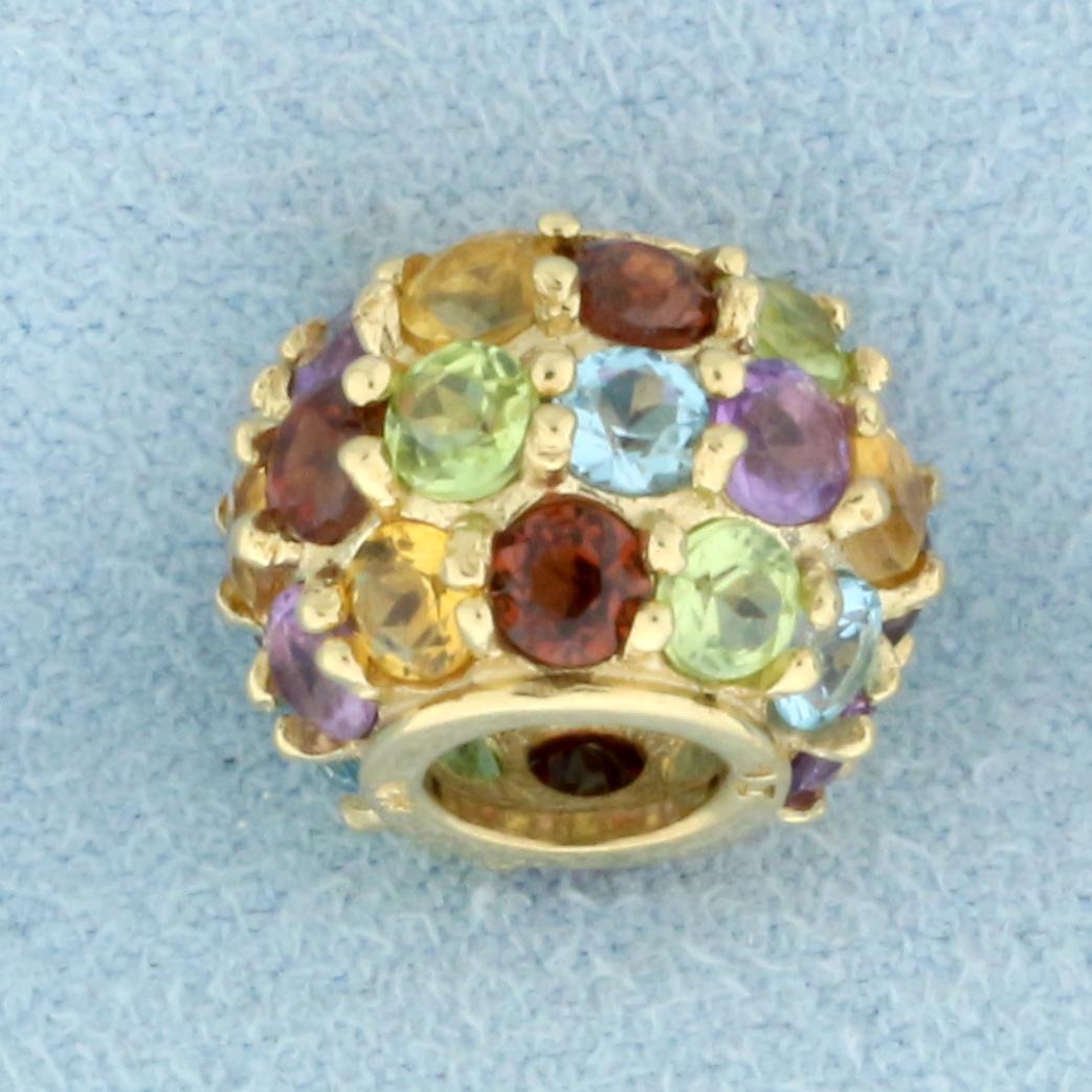 Multi Colored Gemstone Charm Bead In 10k Yellow Gold: In 10k yellow gold. Contains 25 3mm high quality gemstones including amethyst, citrine, blue topaz, peridot, and garnet. All with vibrant color and excellent clarity. 1/2 inch diameter. Can fit on up 