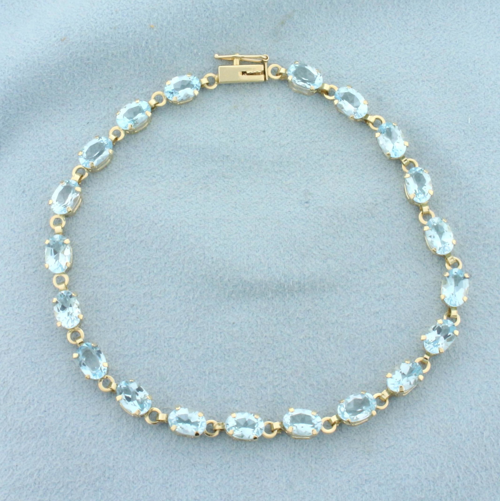 Sky Blue Topaz Line Bracelet in 10k Yellow Gold: In 10k yellow gold. Contains twenty high quality natural sky blue topaz gemstones, 10cts TW, with beautiful pastel blue color and excellent clarity. 7 1/2 inches long. Safety clasp. 5.4g.