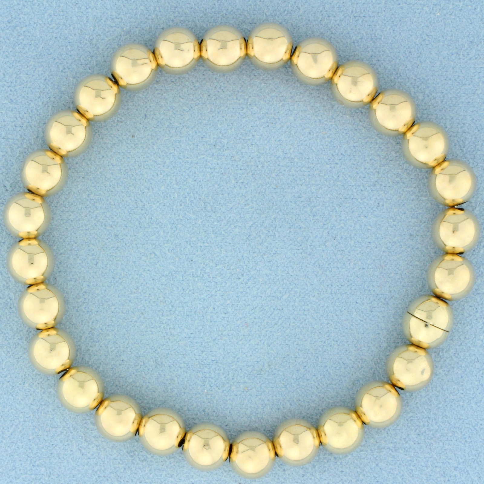 7mm Ball Bead Magnetic Closure Bracelet in 14 Yellow Gold: In 14k yellow gold. 7 1/4 inches long with 7mm ball beads. Concealed magnetic clasp. 6.1g.