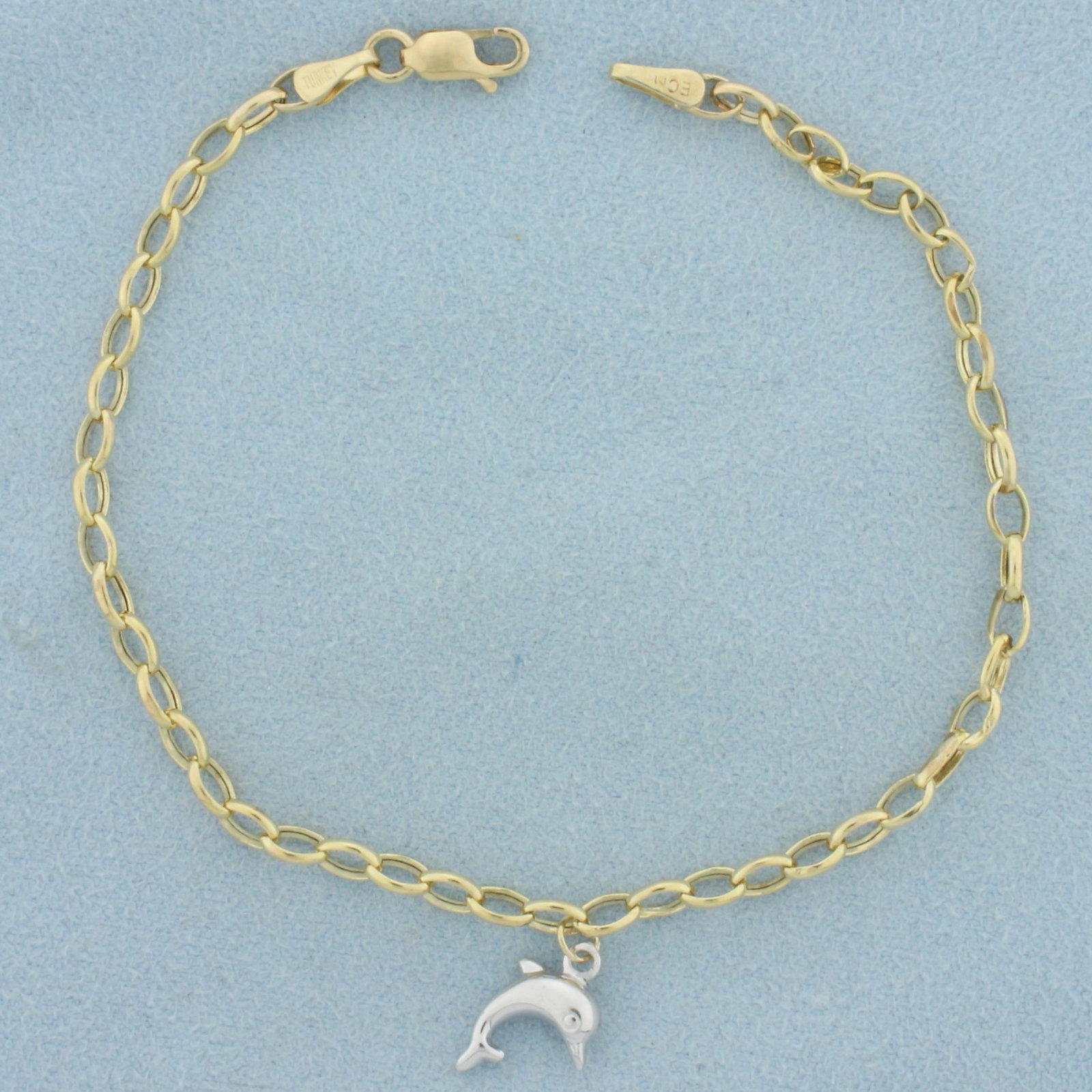 Dolphin Bracelet in 10k Yellow and White Gold: In 10k yellow and white gold. 10k yellow gold bracelet with 10k white gold dolphin. 3mm oval chain link with dolphin charm in middle. Lobster clasp. 1.7g