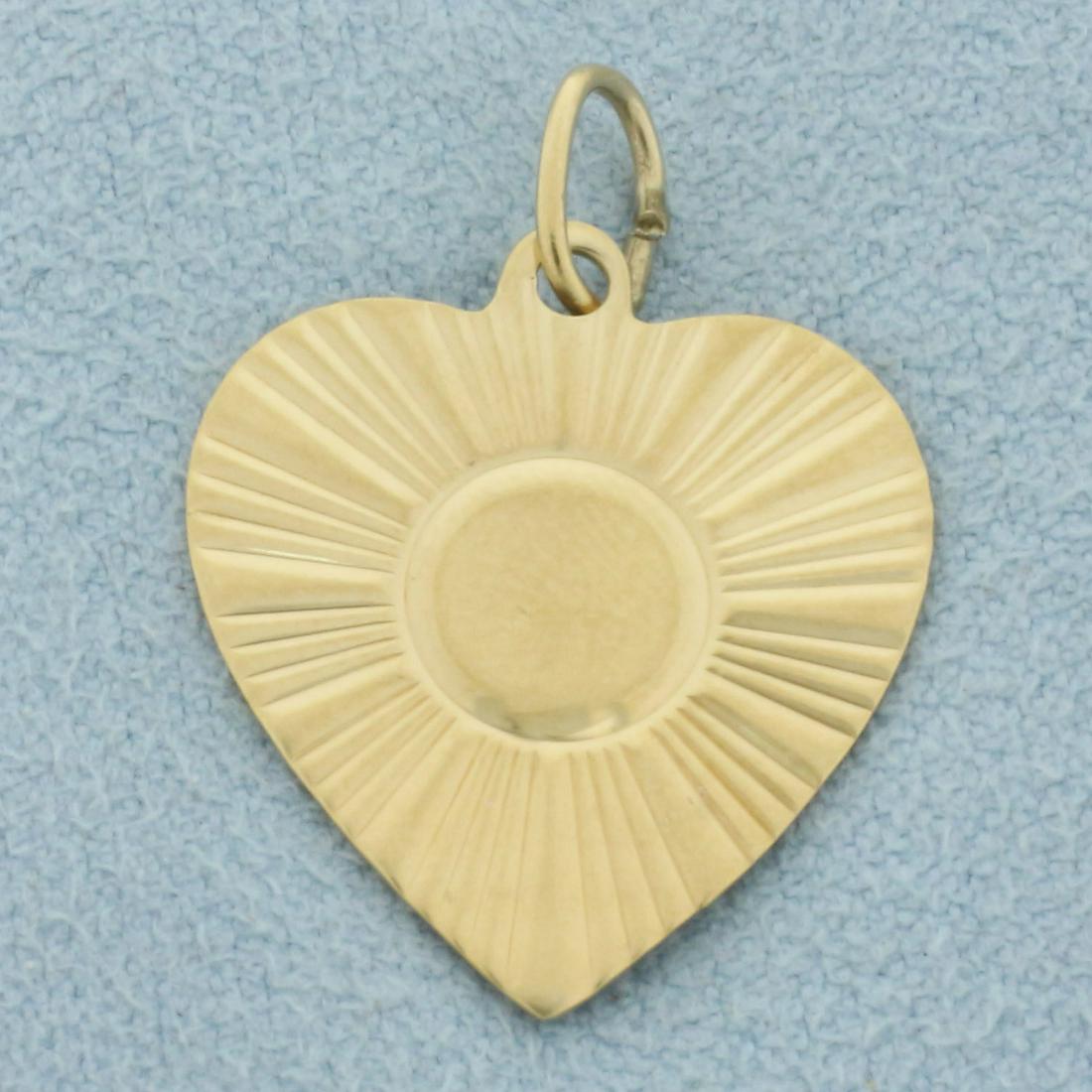 Beveled Engravable Heart Charm or Pendant in 14k Yellow Gold: In 14k yellow gold. 1 inches long (including jump ring) by 5/8 inches wide. Beveled gold for added reflection. 1.5g.