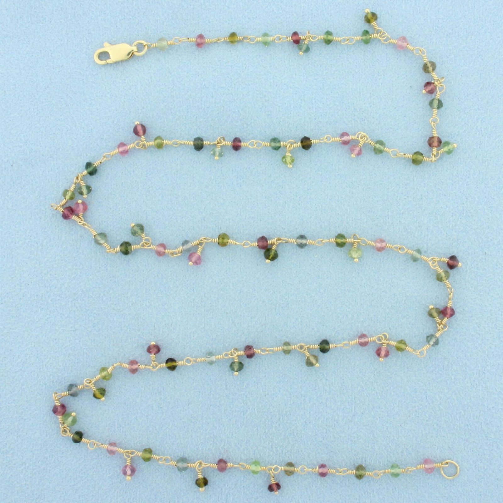Rainbow Colored Gemstone Necklace in 14k Yellow Gold: In 14k yellow gold. 20 inches long. Contains 3mm high quality gemstones including Morganite, Amethyst, Peridot, and Blue Topaz. Lobster clasp. 7.2g.