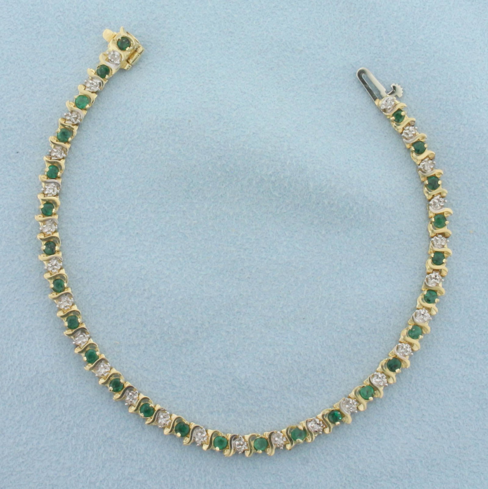 Emerald and Diamond Tennis Bracelet in 10k Yellow Gold: In 10k yellow gold "Contains twenty six high quality 1/2pt diamonds. Also contains twenty six high quality natural 2.5mm emeralds with vibrant green color. 7 Inches long. Safety clasp.