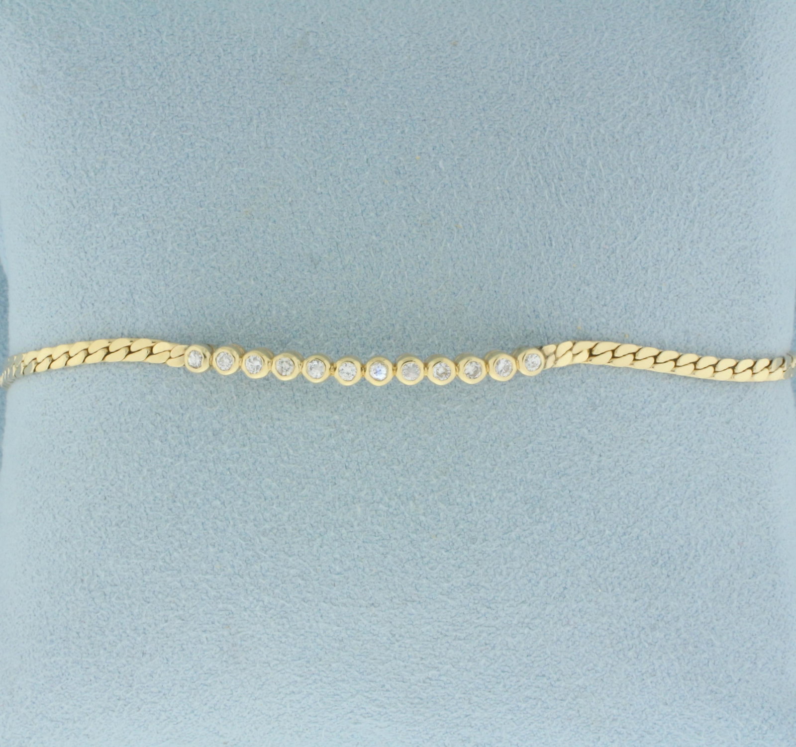 Bezel Set Diamond S-Link Bracelet in 14k Yellow Gold: In 14k yellow gold. Contains 12 high quality round brilliant diamonds, 1/3ctw, SI clarity/H color. 6 3/4 inches long, 2.25mm wide . Barrel clasp and safety latch. Safety chain. 5.3g.