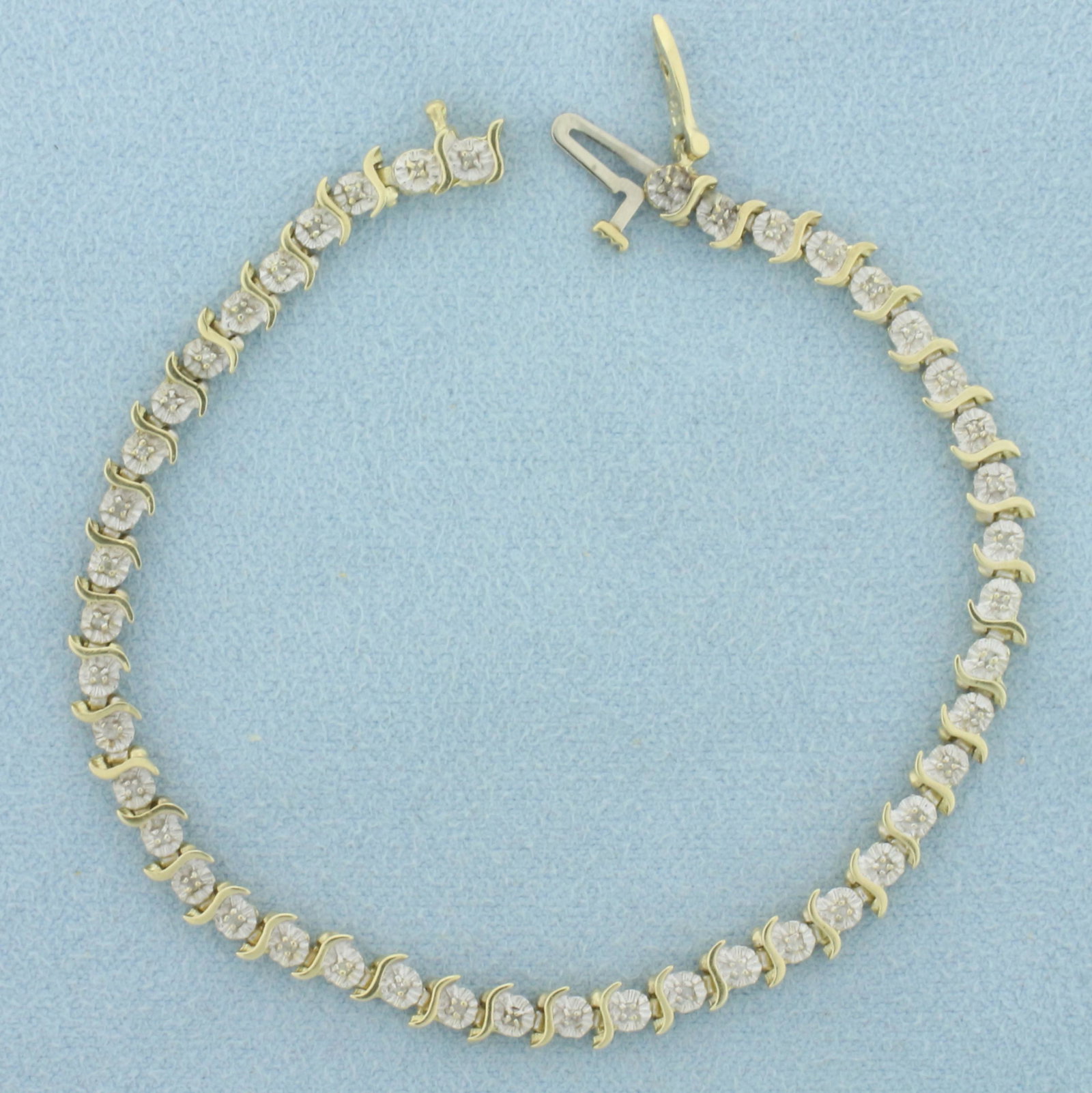 Diamond S Link Tennis Line Bracelet in 10k Yellow and White Gold: In 10k yellow and white gold. Features 45 high quality 1/2pt diamonds. Measures 4.2mm wide and 6 3/4 inches long. White gold is fashioned to give illusion or larger diamonds. Concealed slide closure w