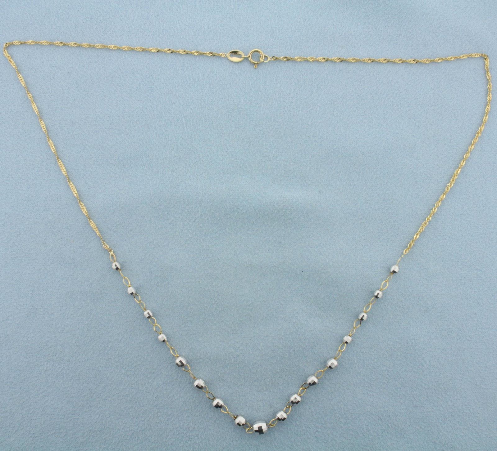 Italian 18 Inch Disco Hex Graduated Ball Bead Station Necklace in 14k Yellow and White Gold: In 14k Italian yellow and white gold. Measures 5mm in diameter at largest ball bead. Singapore chain measures 18 inches long, 1.4mm wide. Spring clasp. 2.7g.