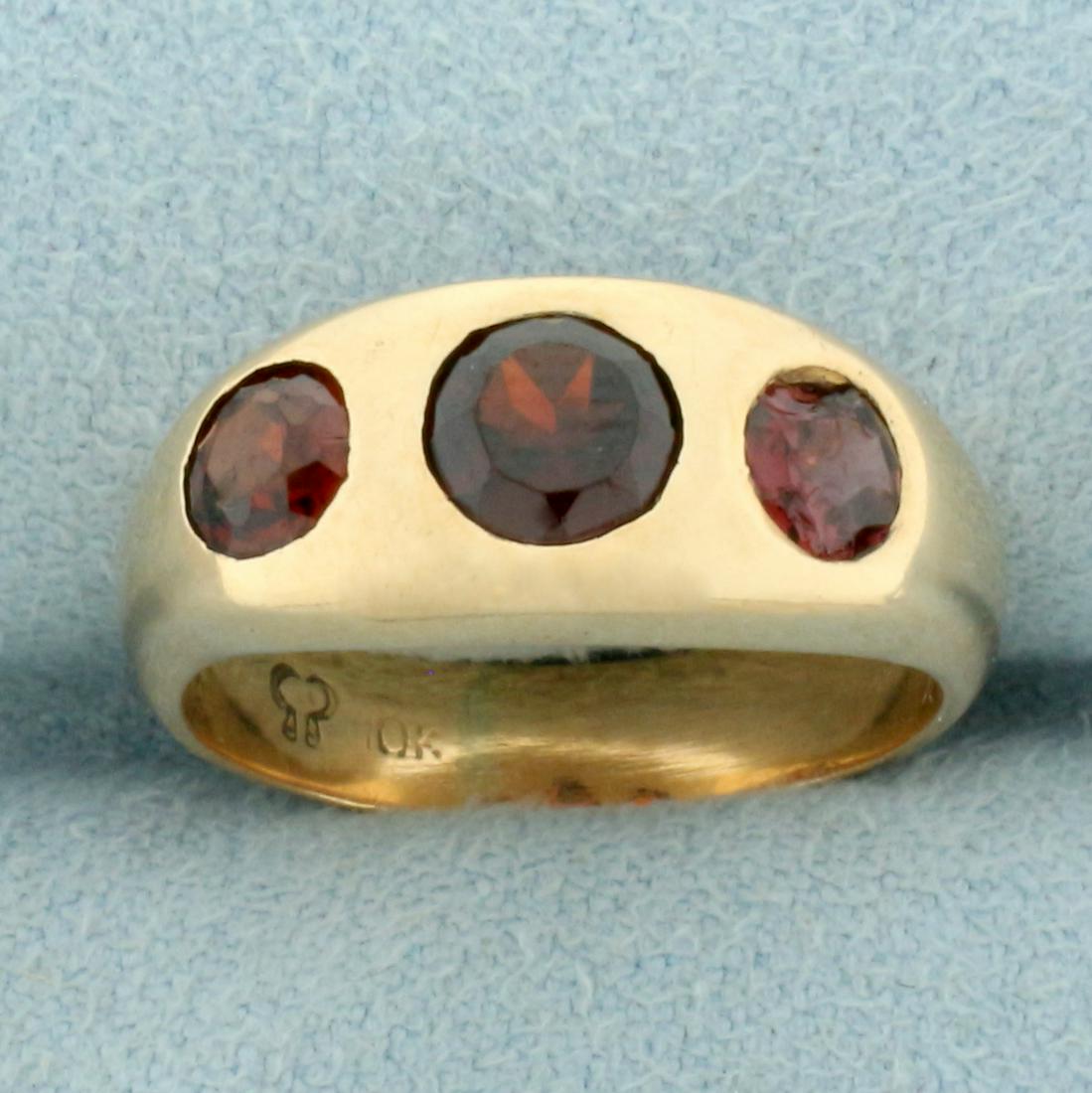 Antique Garnet Gypsy Set Three Stone Ring in 10k Yellow Gold: In 10k yellow gold with rose undertone. Contains one 5mm and two 4mm high quality garnet gemstones with deep color and excellent clarity. One garnet is chipped (wear is consistent with age). Size: 5.2